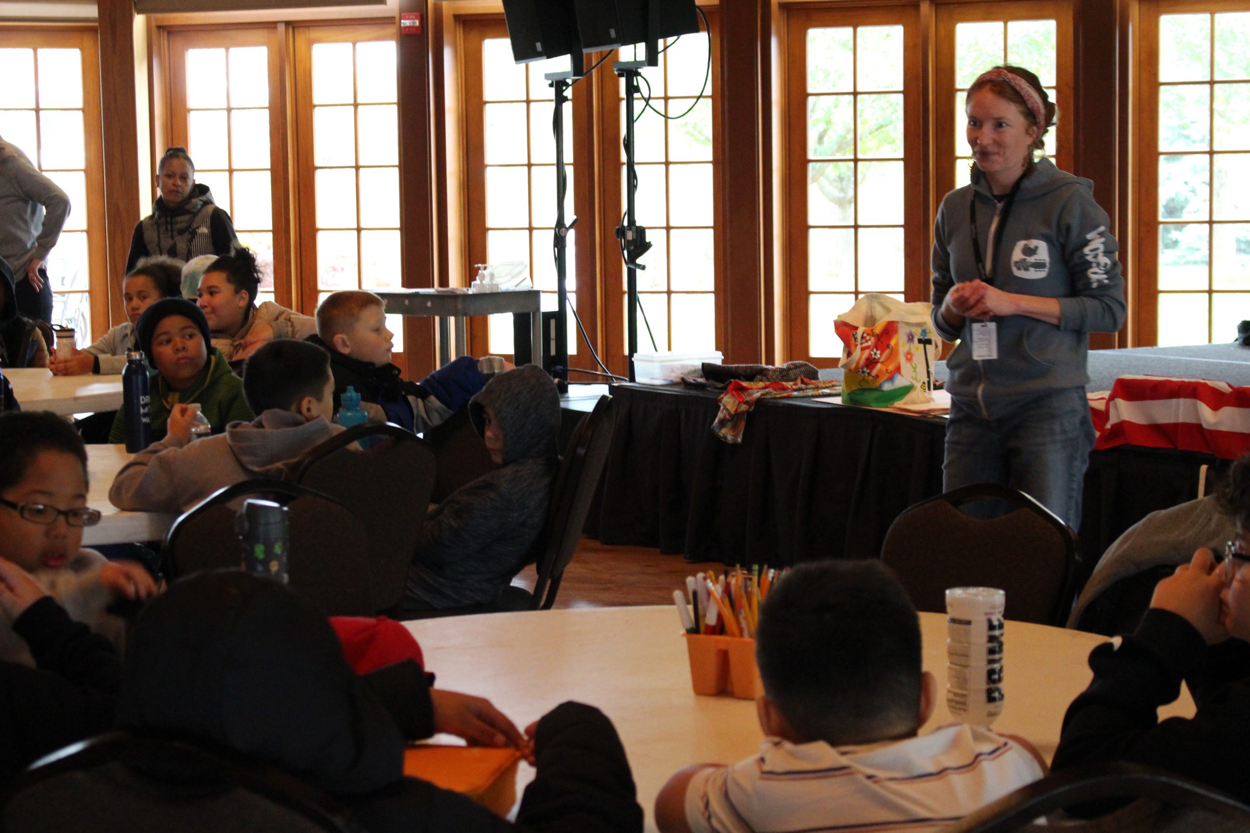 a woman is leading a presentation in front of a group of students. 