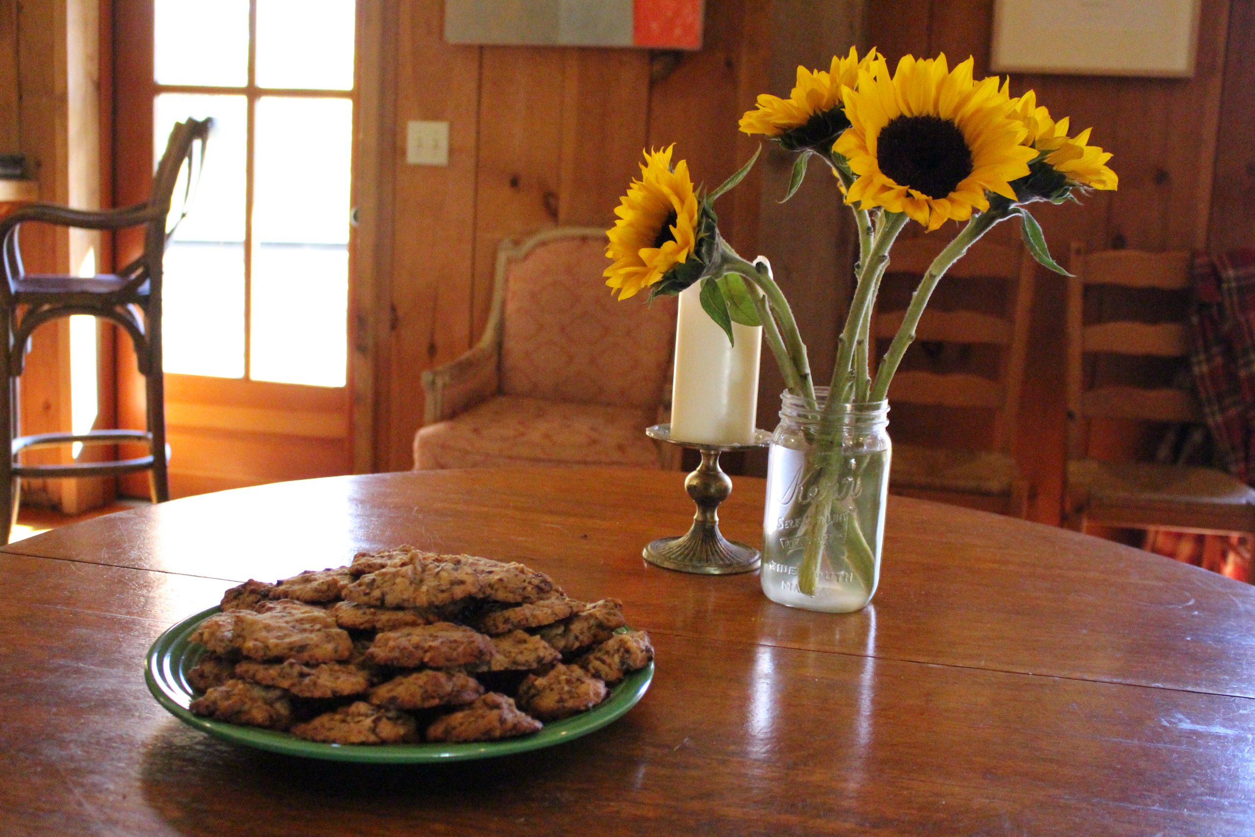 sunflowers and a plate of cookies on a table