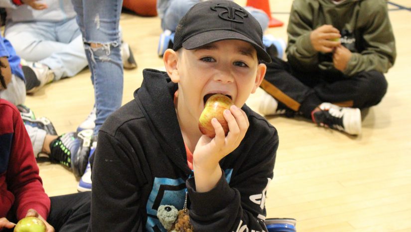 a student is biting into an apple