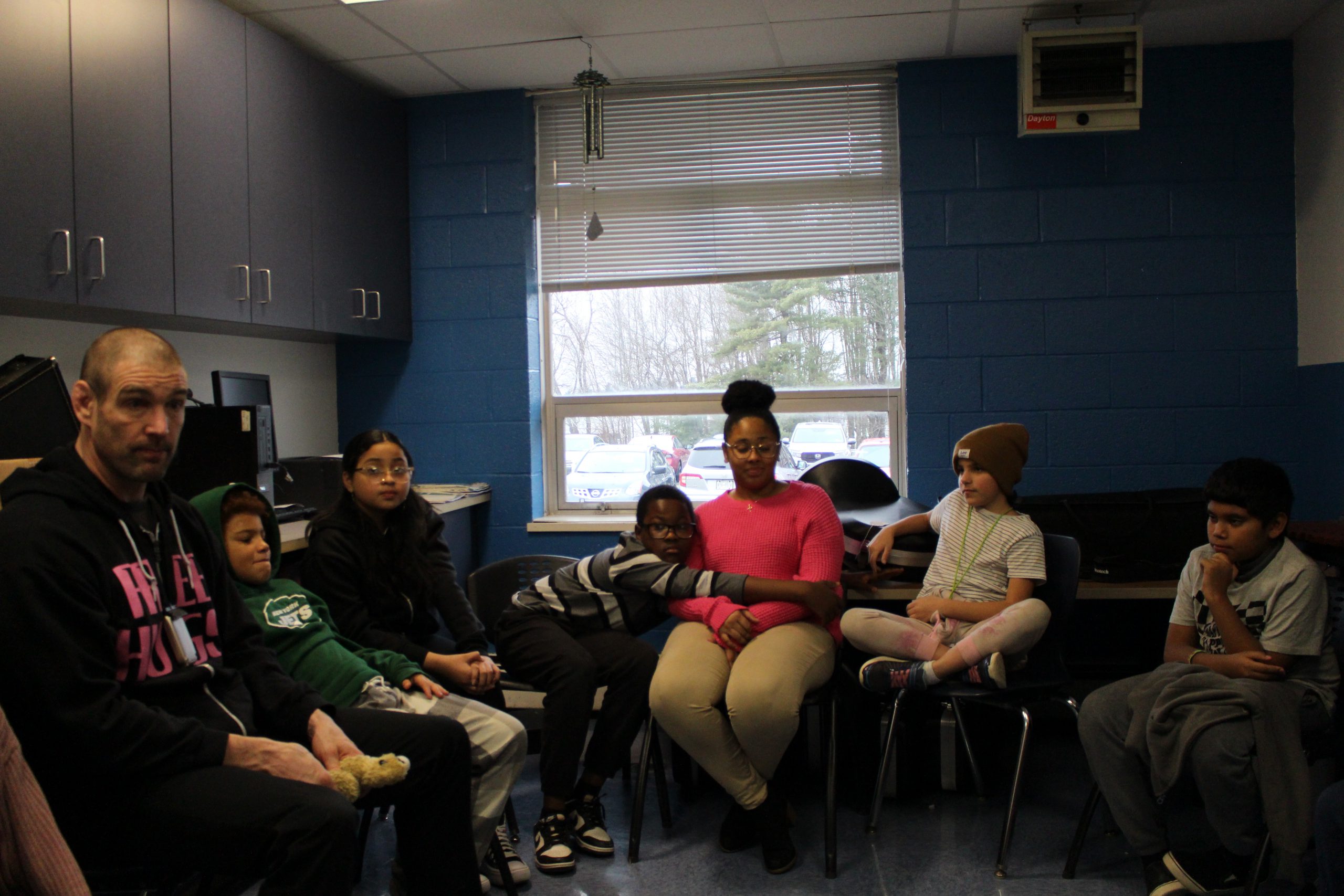 students are sitting in a circle and talking to one another 