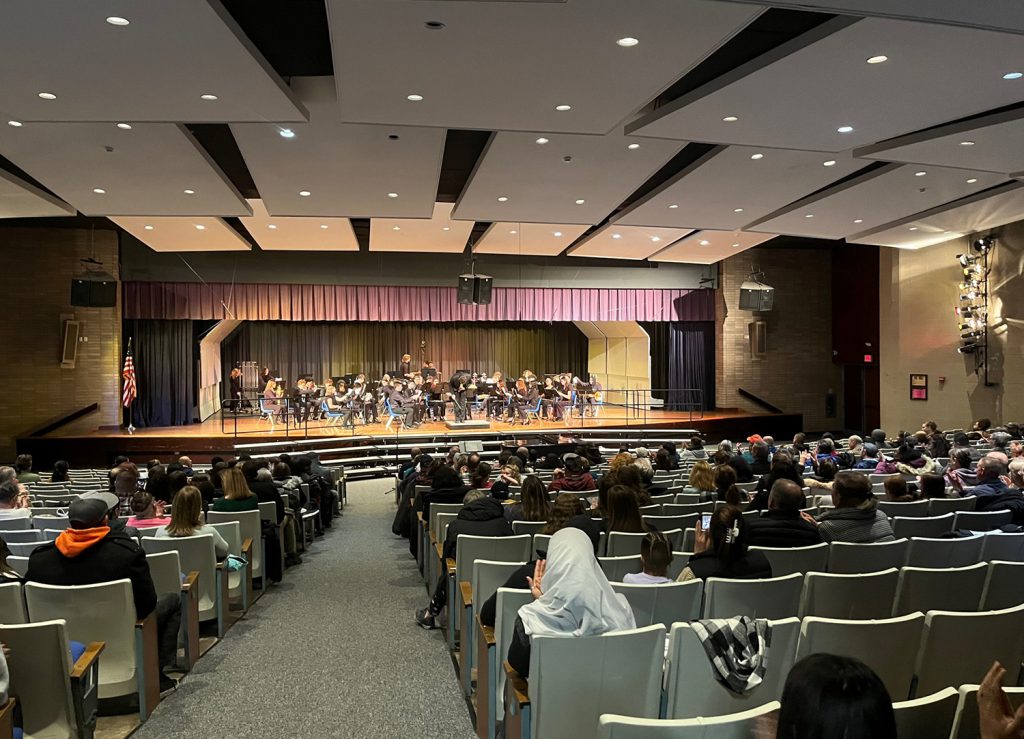 Wide shot of Winter Concert audience and student musicians on stage.