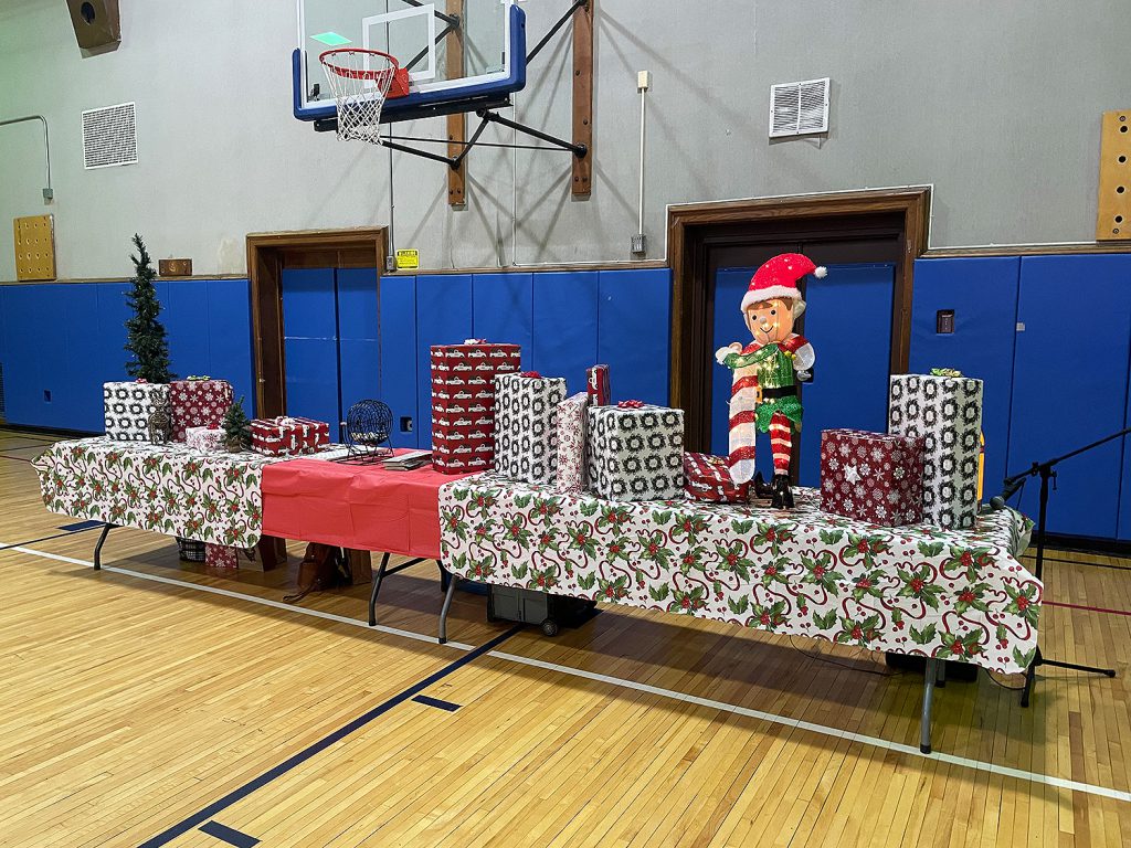 Table in school gym decorated with various holiday decorations.