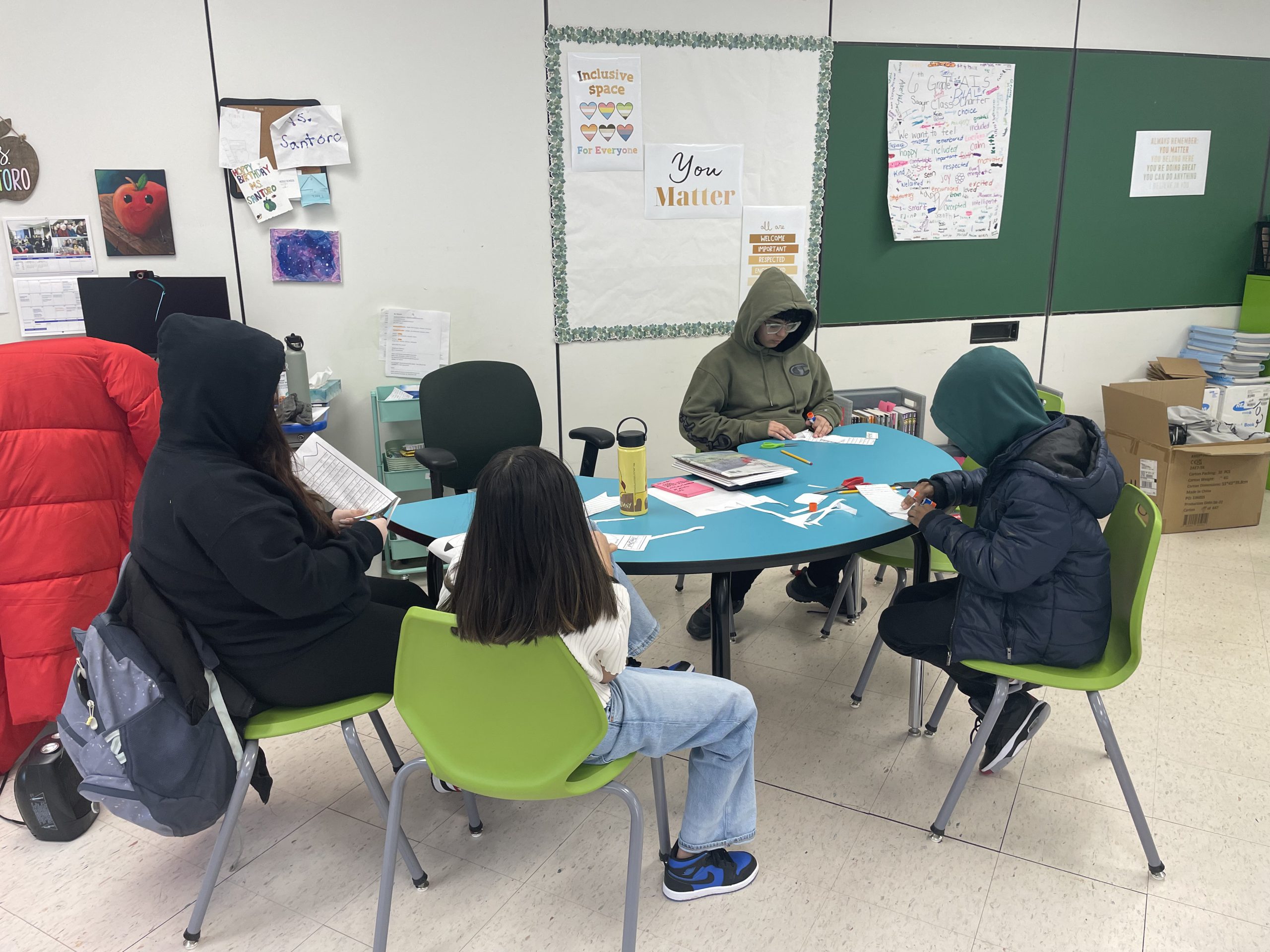 a group of students are seated around a table 