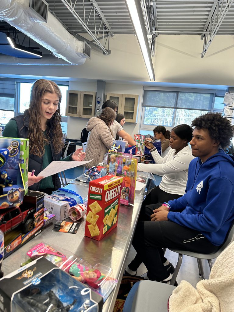 Students wrapping gifts in a classroom.