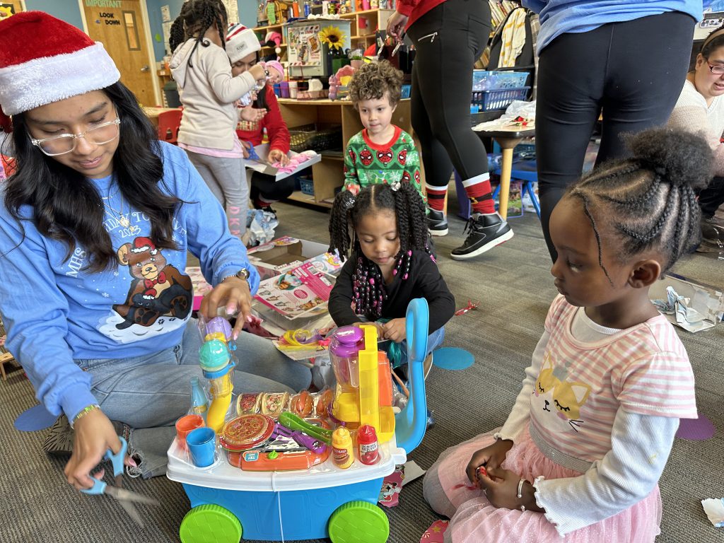 High school student playing with three and four year old students.