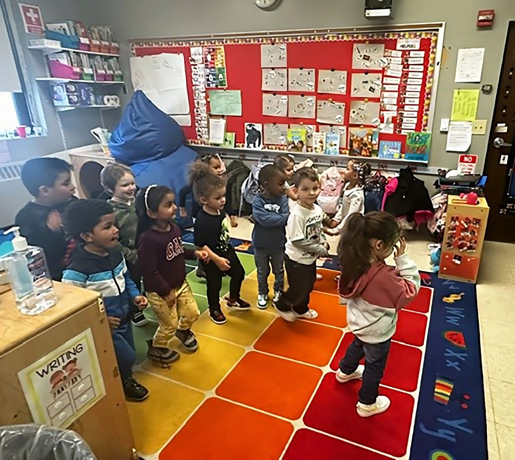 Preschool students standing in the classroom.