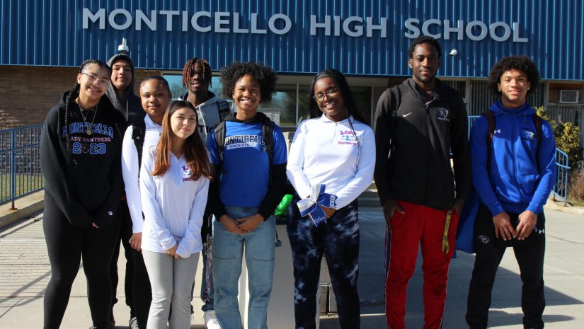 a group of students are standing in front of the entrance to Monticello High School