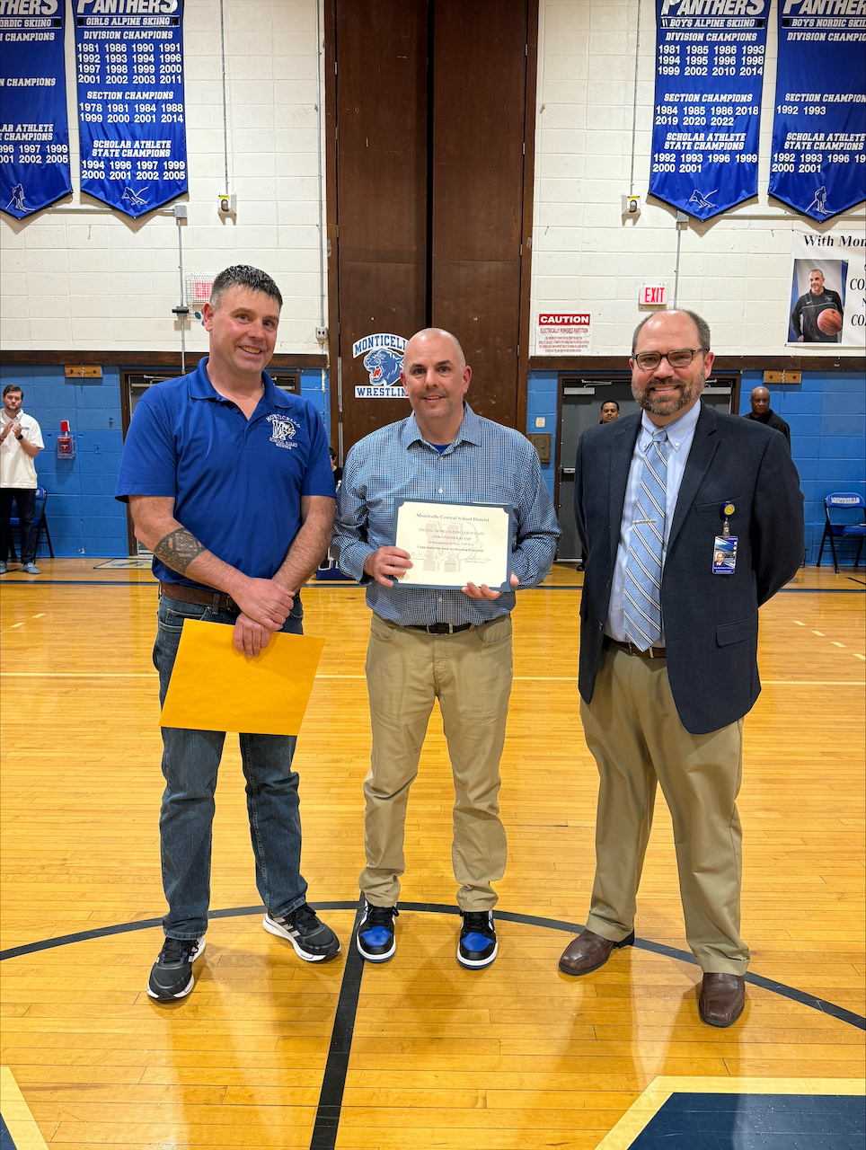 Coach Chris Russo holds his award. On either side are the Board of Education President and the Superintendent 