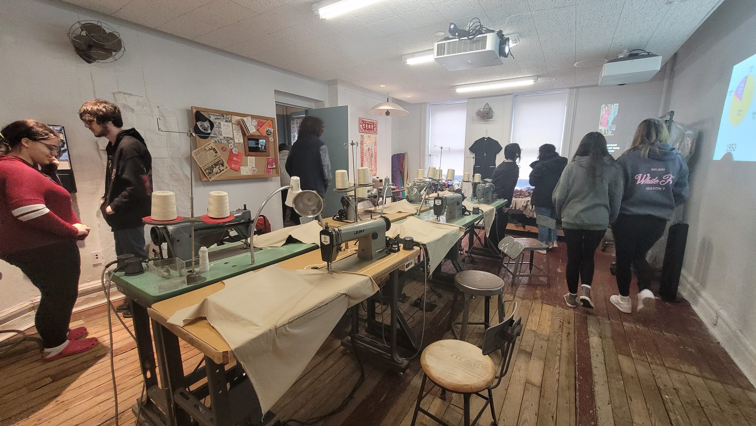 a group of students are exploring a room in the tenement museum. 