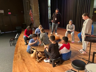 a group of students are on stage with instruments