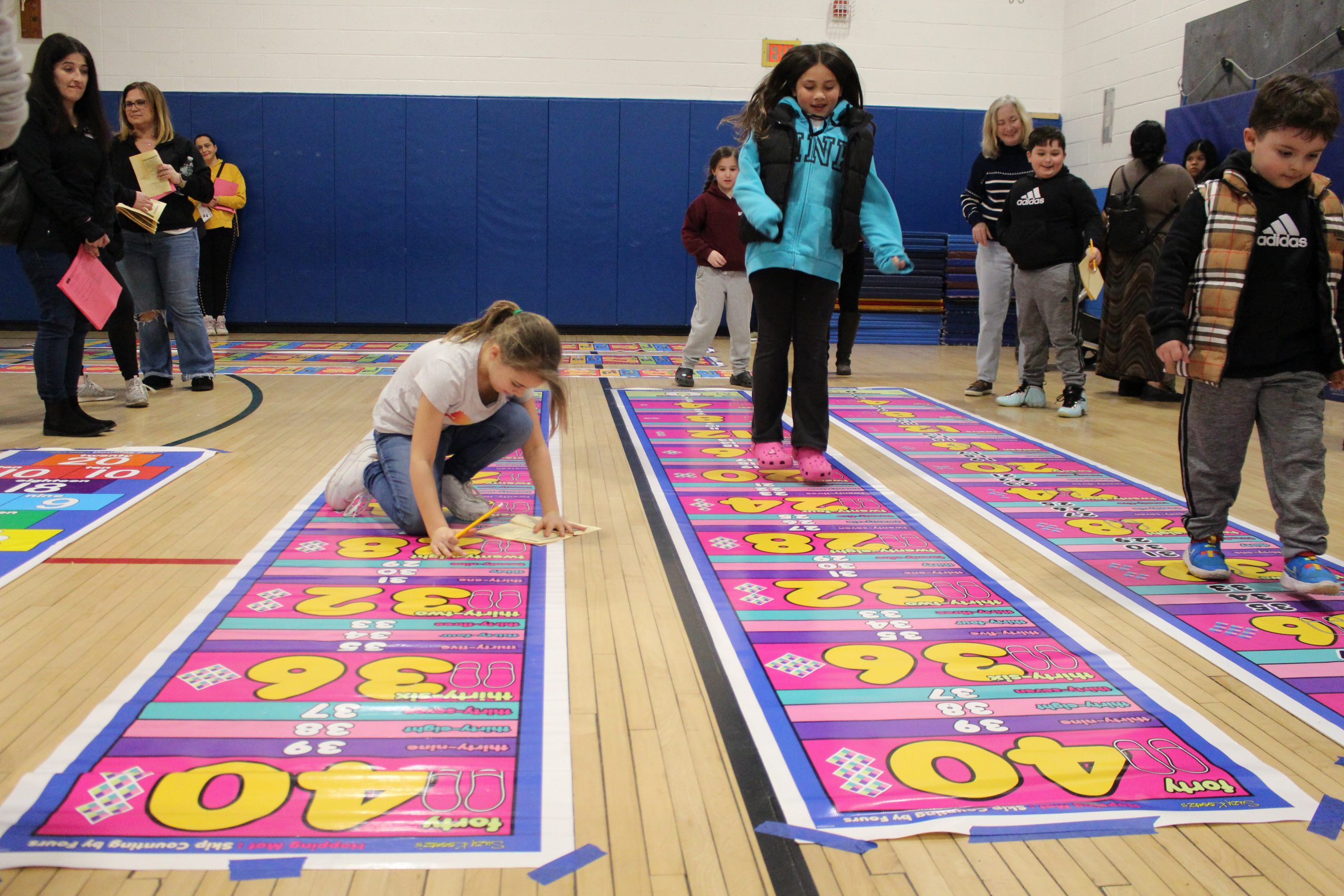 a student hops down a hopscoth-like bright mat