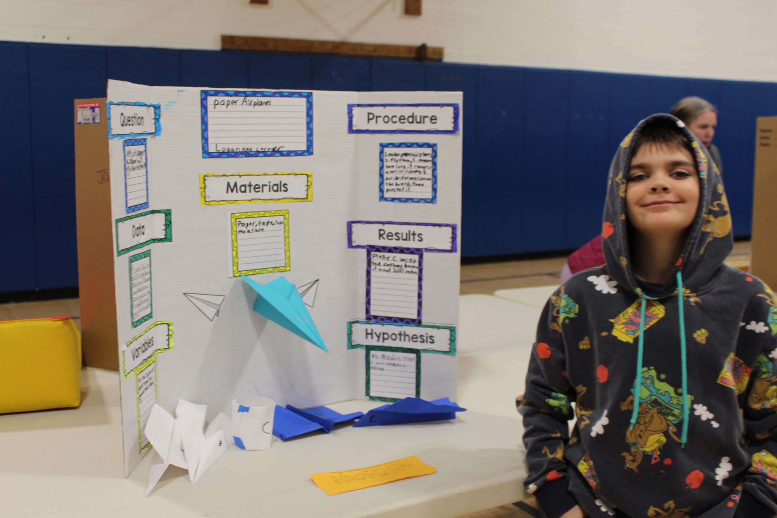 a student stands next to the presentation he created