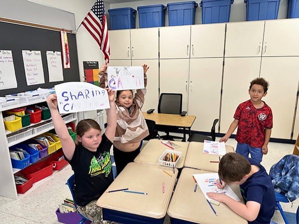 Students holding their posters up for the camera.