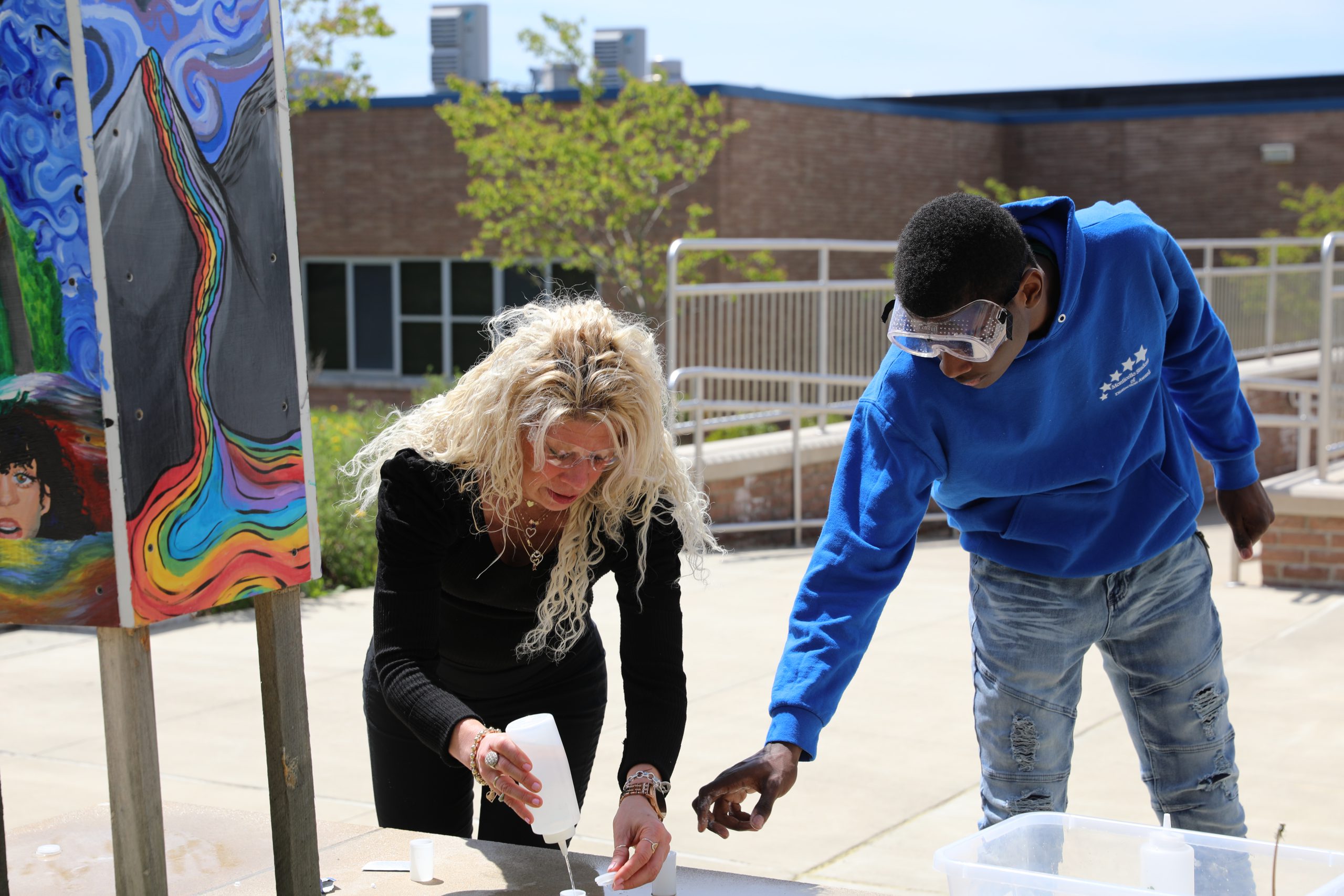 Ms. Mathern is helping a student mix together chemicals 