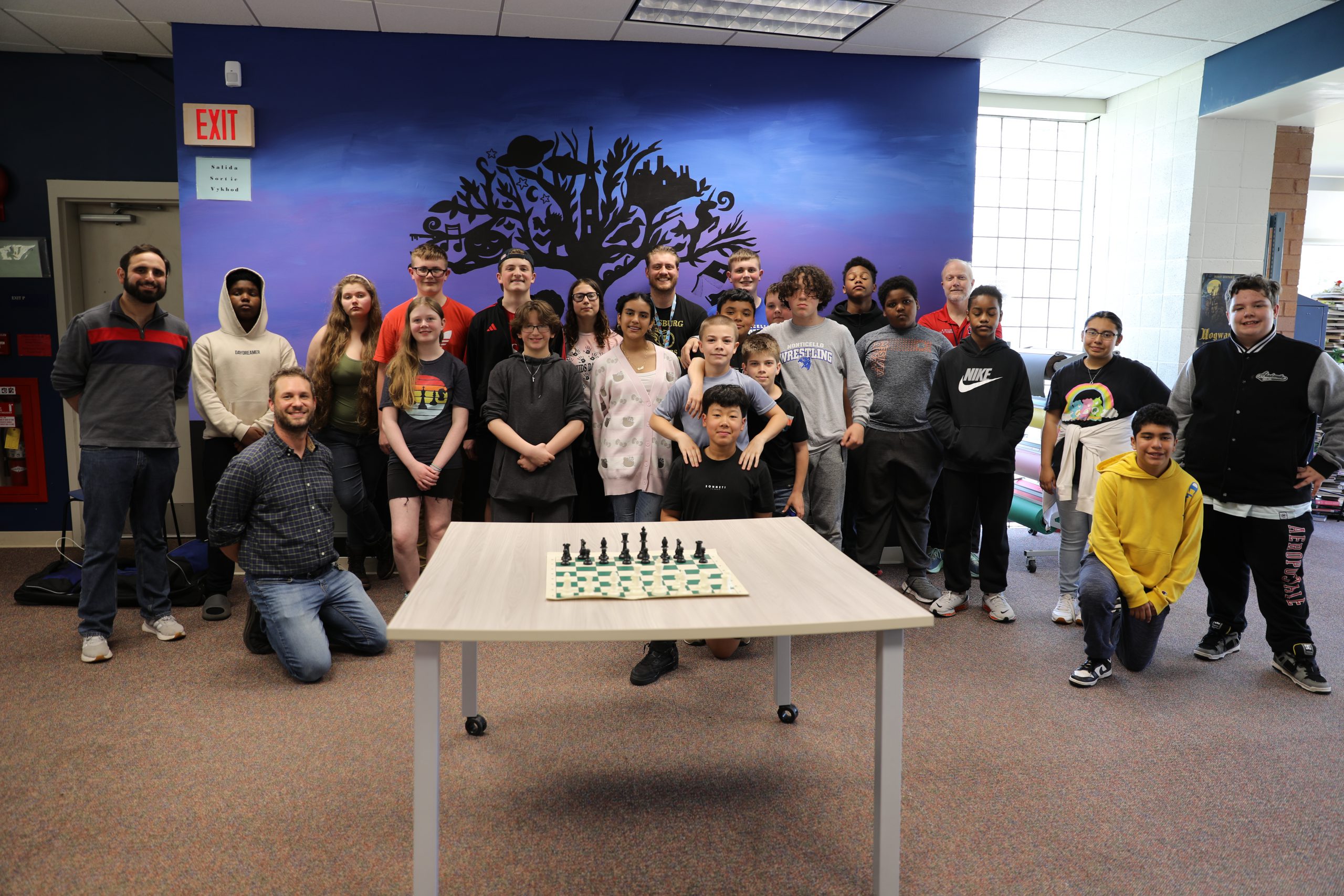 a group of students are posing in front of a chess board