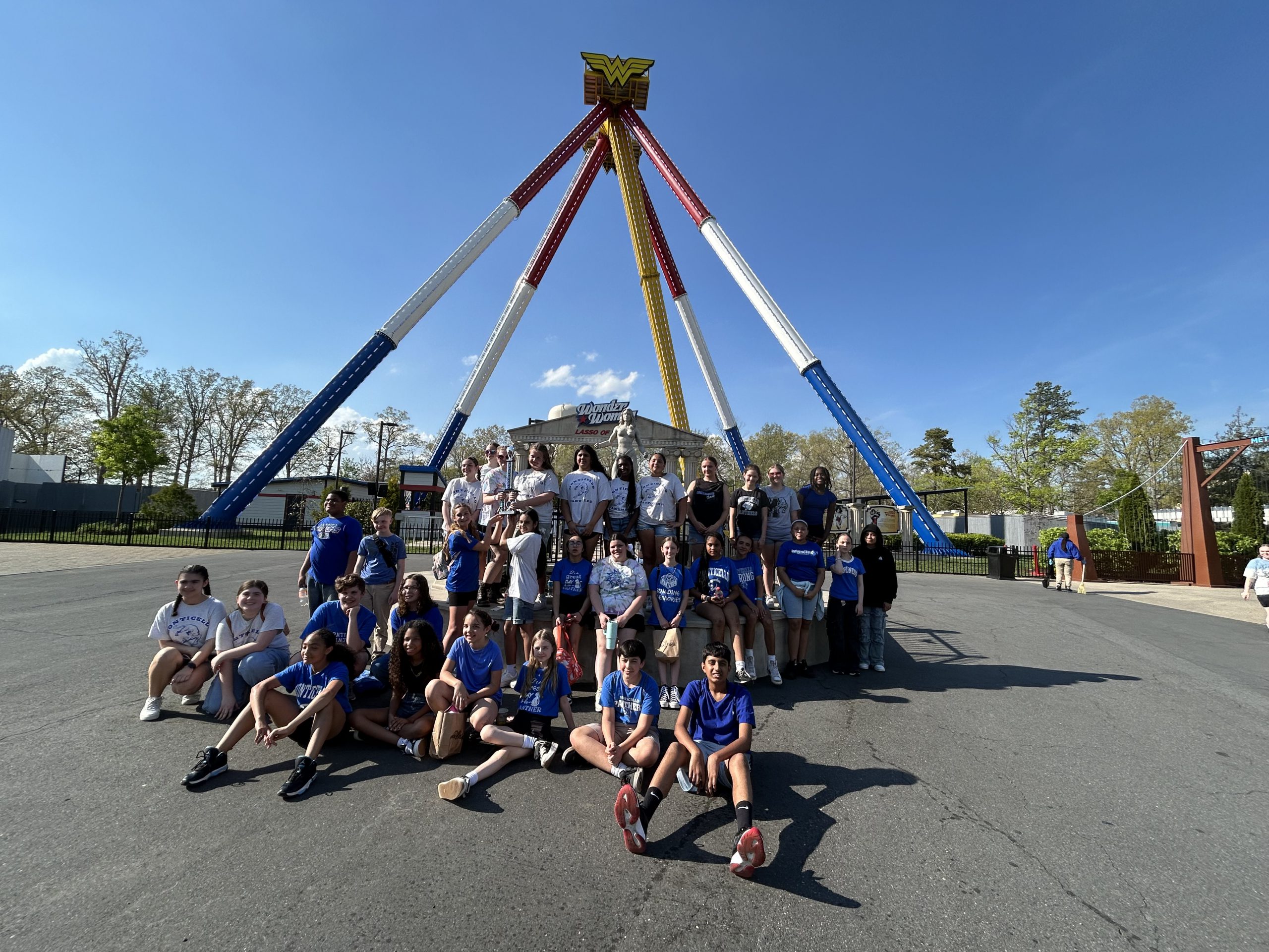 A group of students are posing in front of a ride 