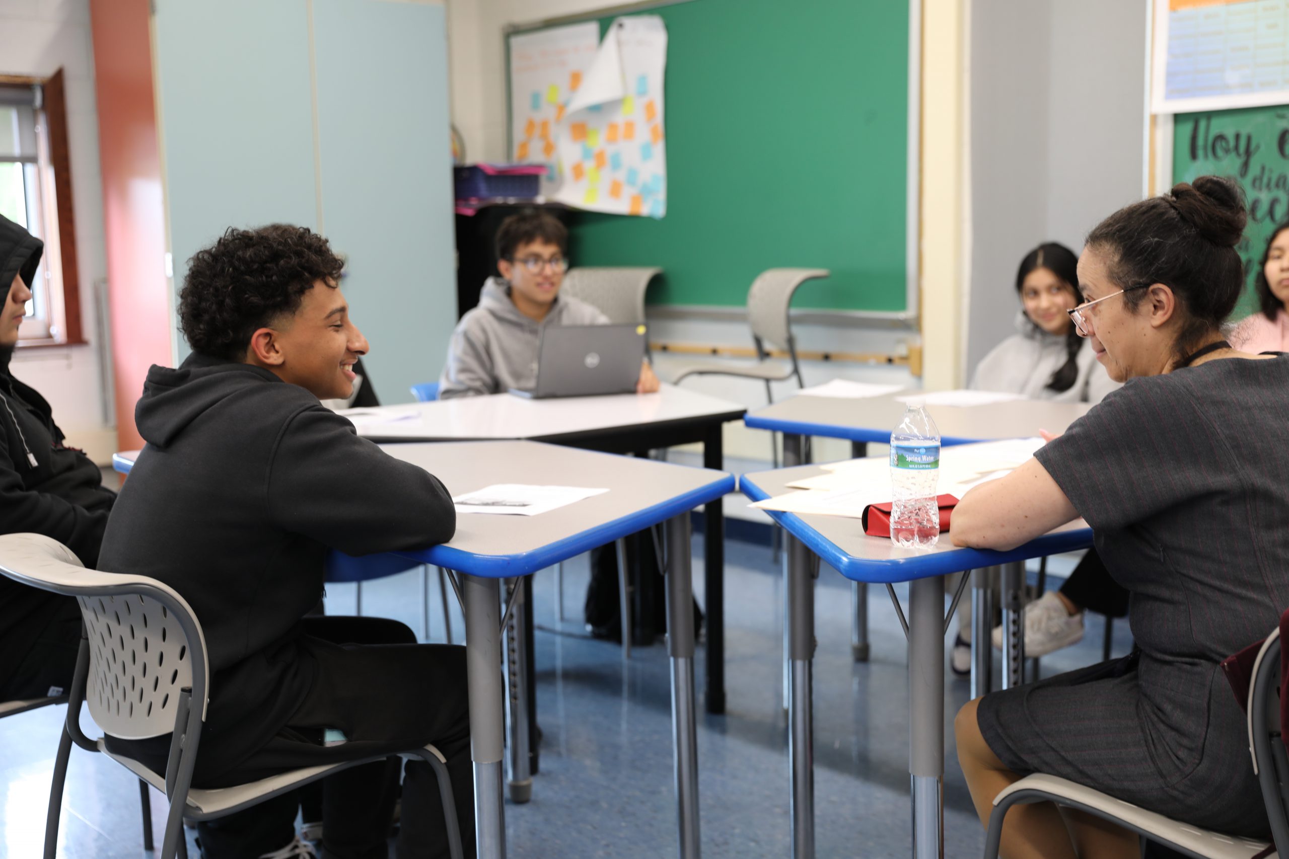 a student and teacher are seated at a desk