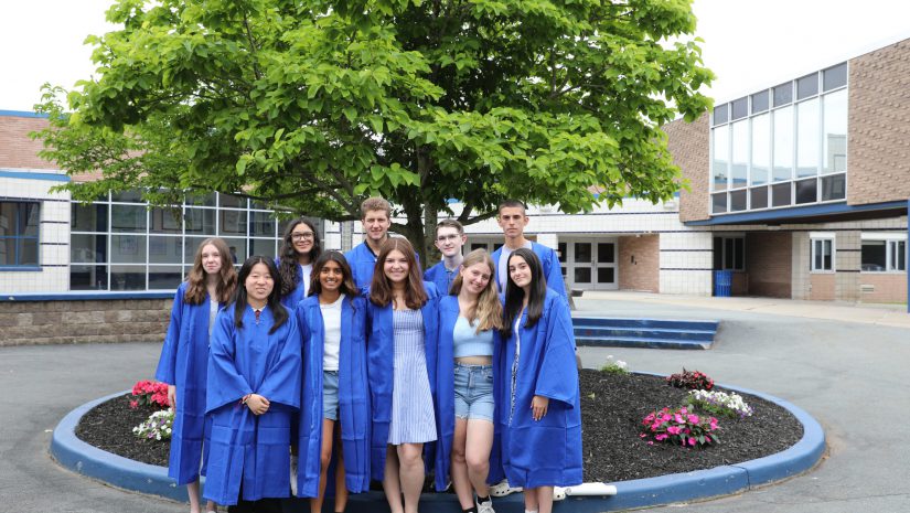 the top 10 seniors in the class of 2025 are posing in a group in the high school courtyard.