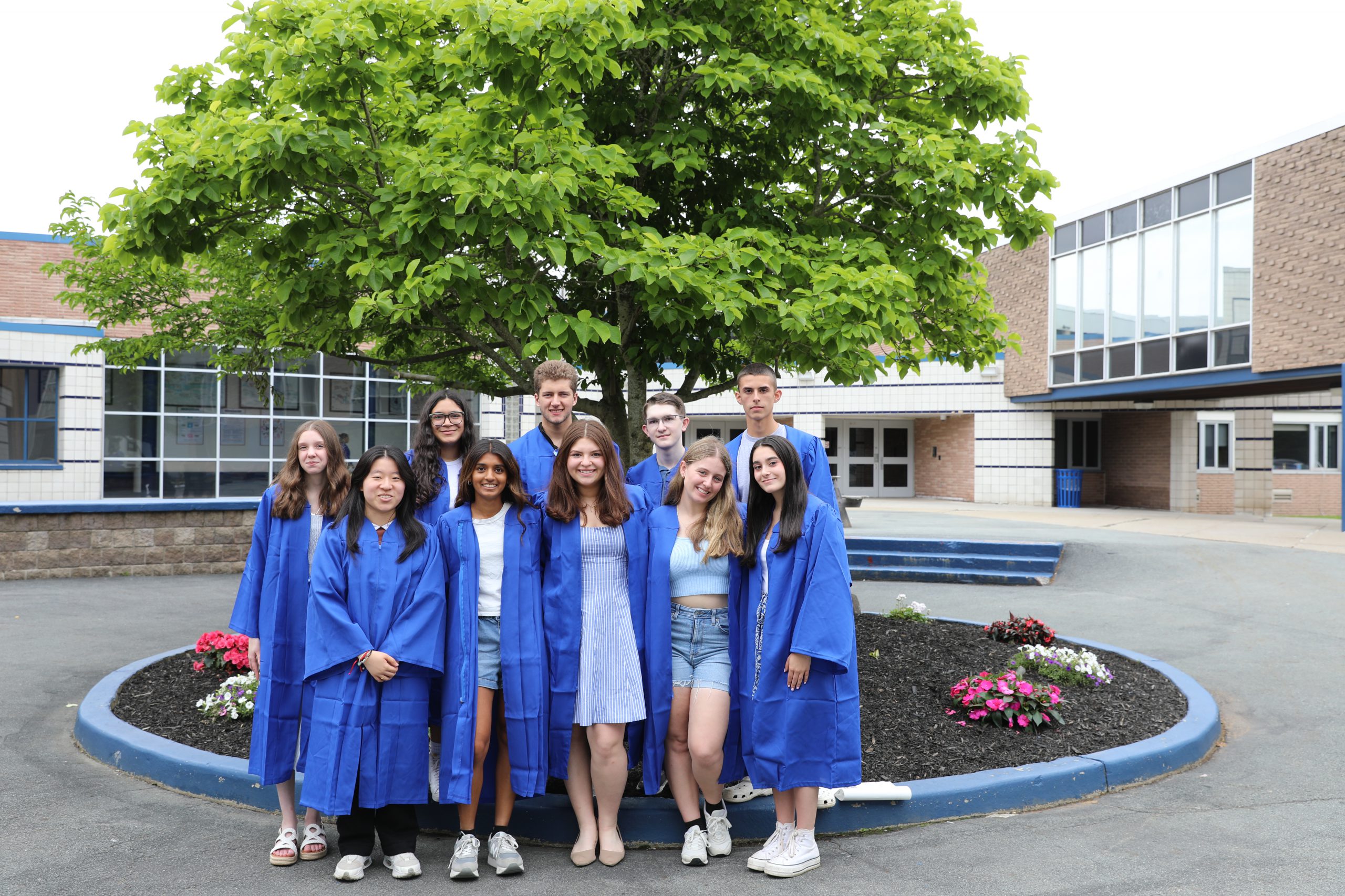 the top 10 seniors in the class of 2025 are posing in a group in the high school courtyard.