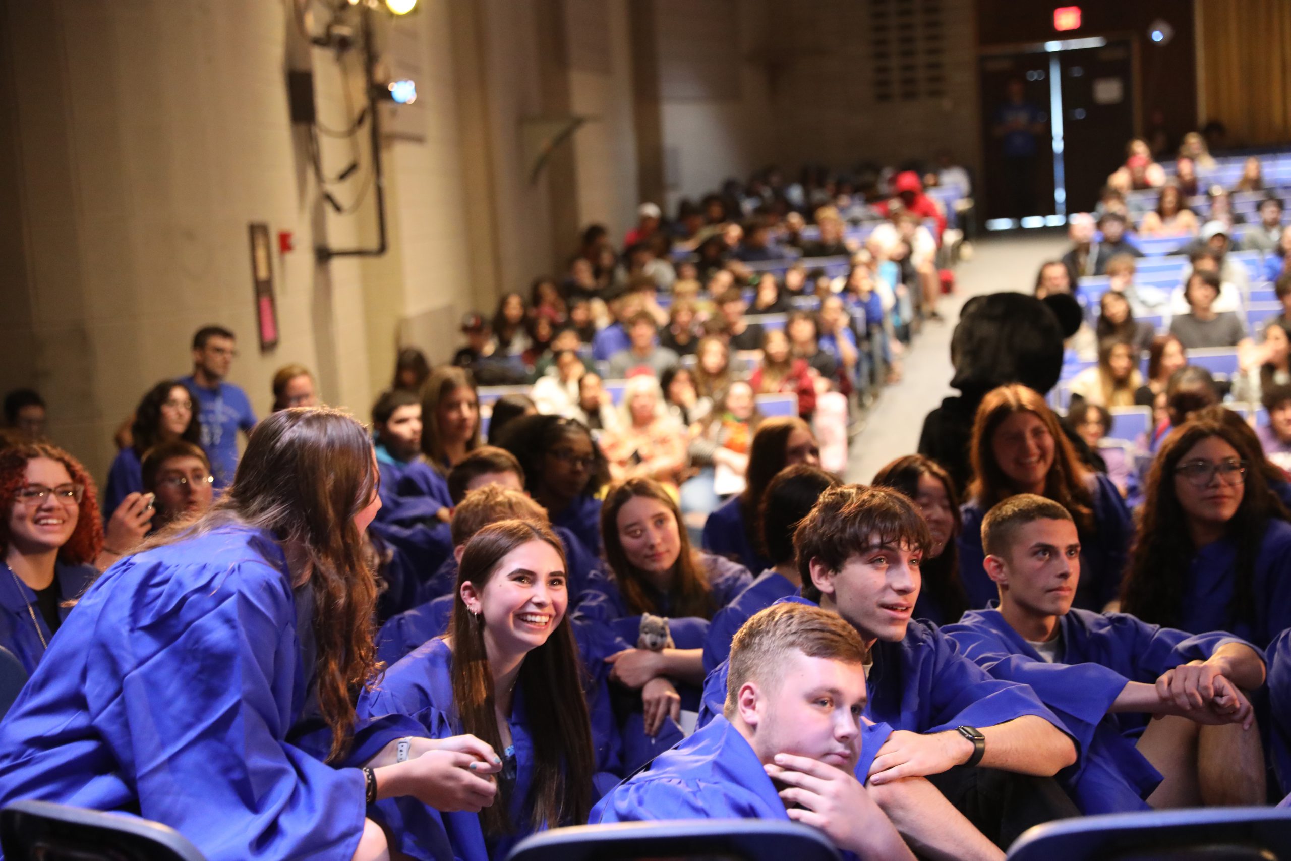 a group of students are watching a screen on stage