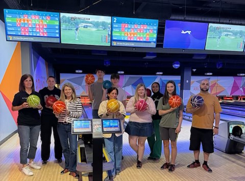 Aof mentors and mentees pose with bowling balls