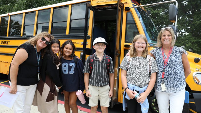 a group of teachers and students are posing near a bus