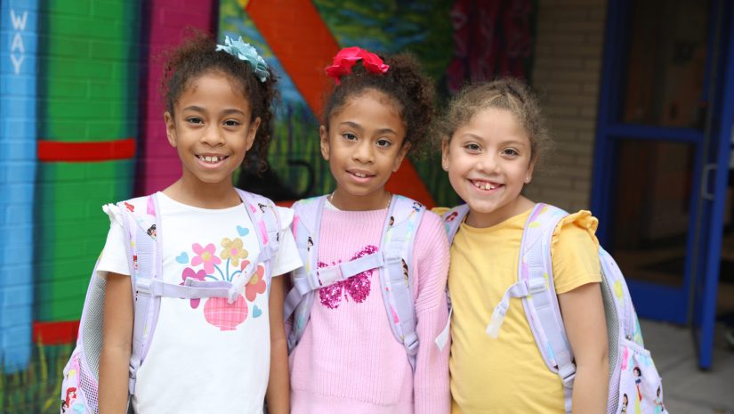 three students smile for the camera