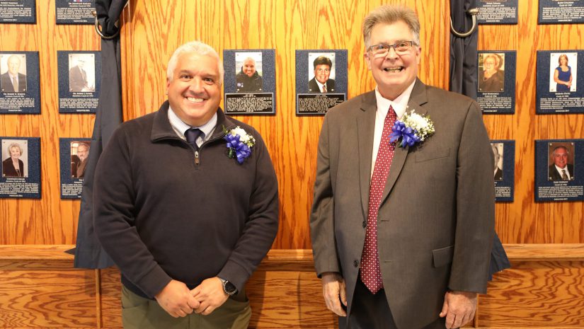 Alex Cabrero, left, and Daniel L. Briggs, right, stand in front of their plaques