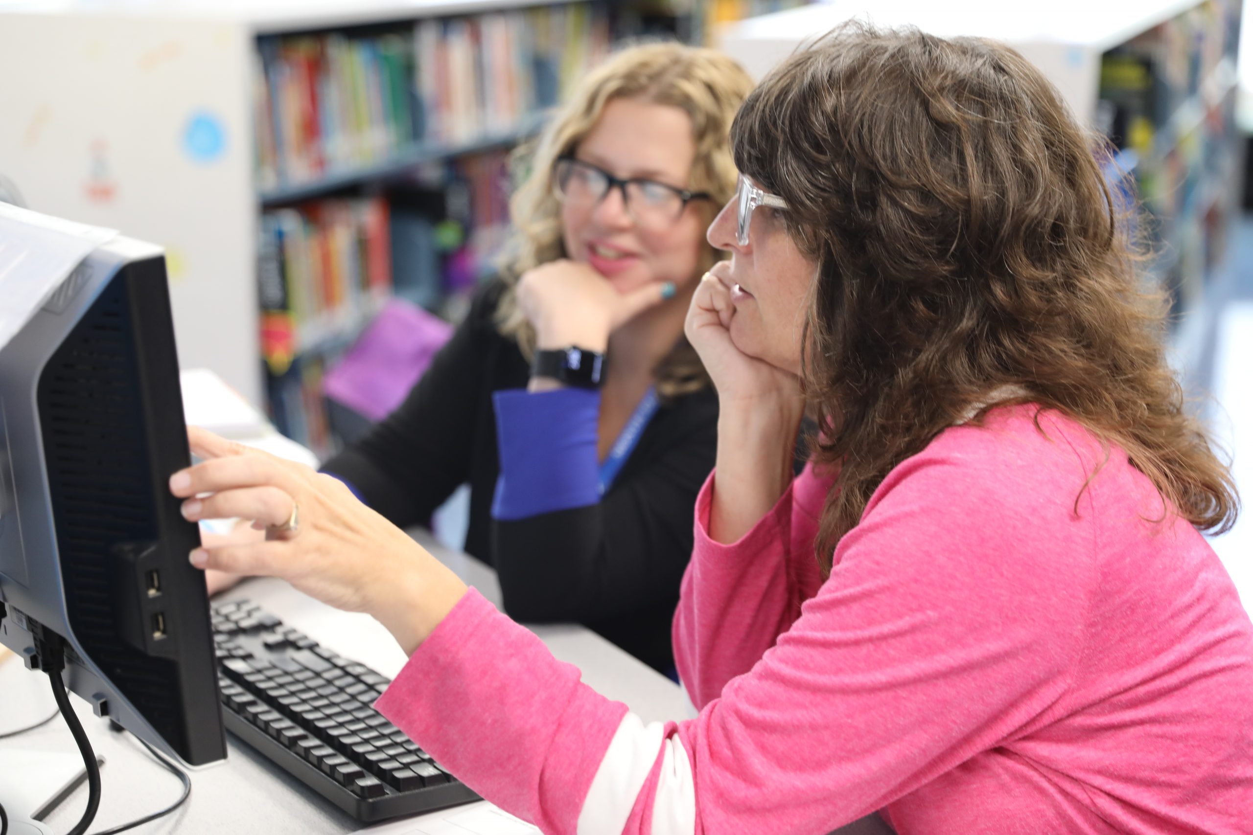 two teachers are looking at a computer