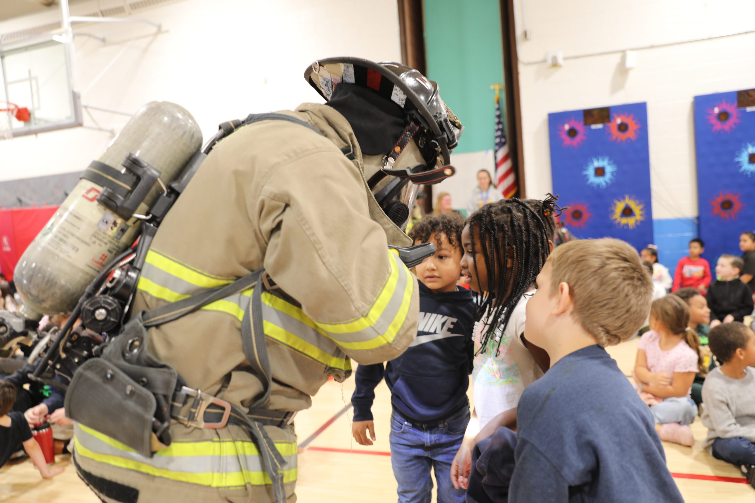 students examine a firefighter's gear