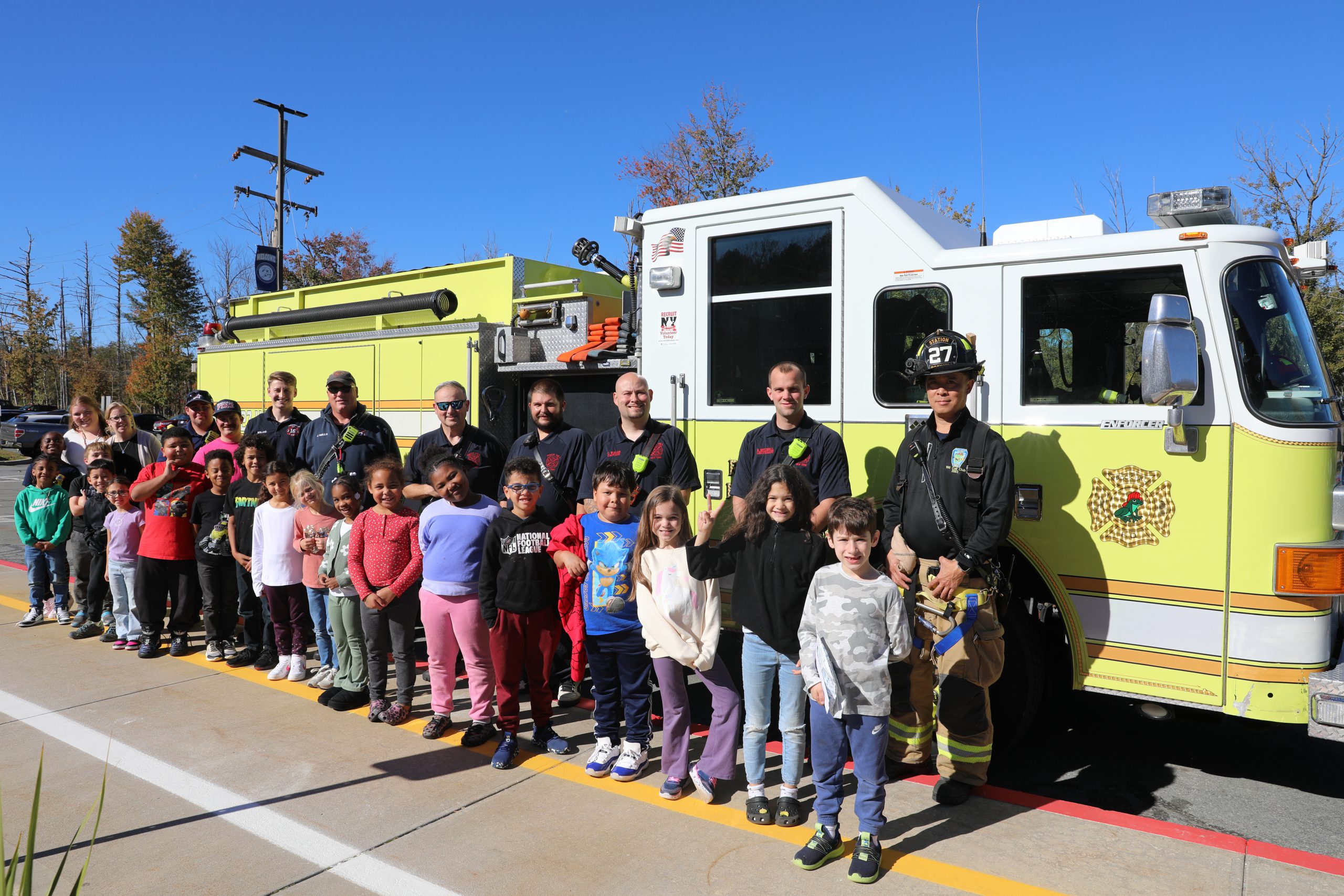 a group of students are firemen are posing in front of a truck