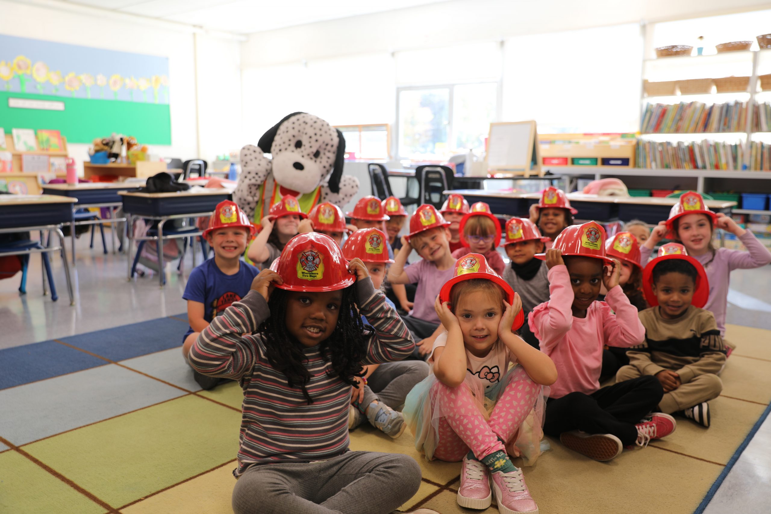 a group of kindergartners wear fire hats