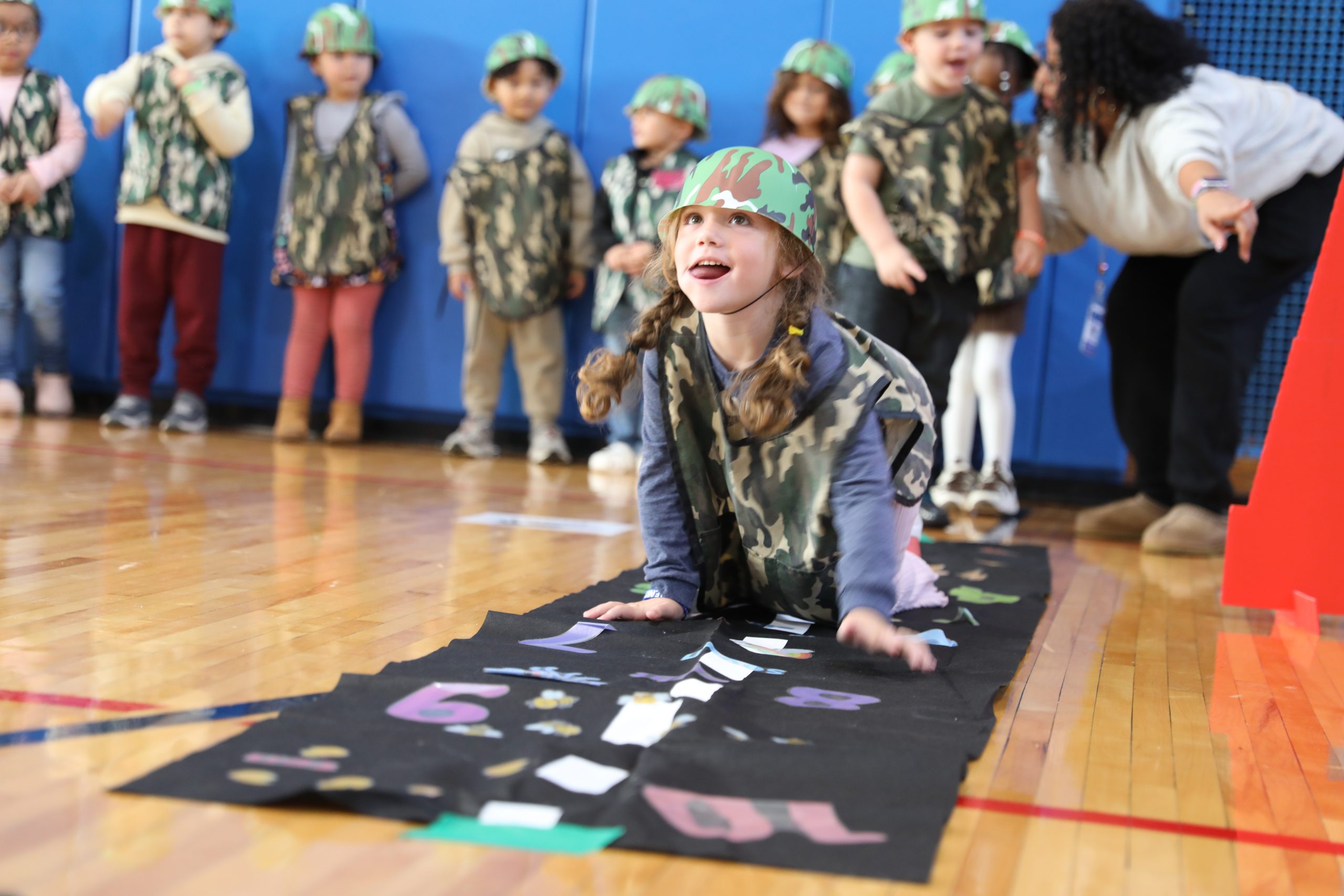 a student crawls through an obstacle course 