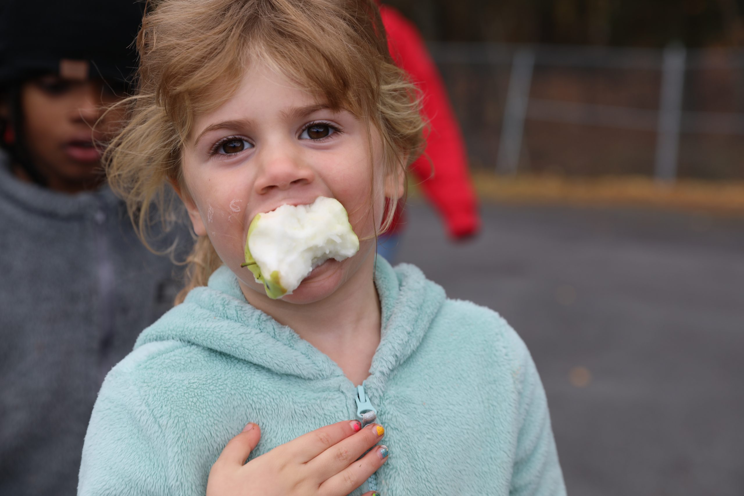 a girl is eating an apple