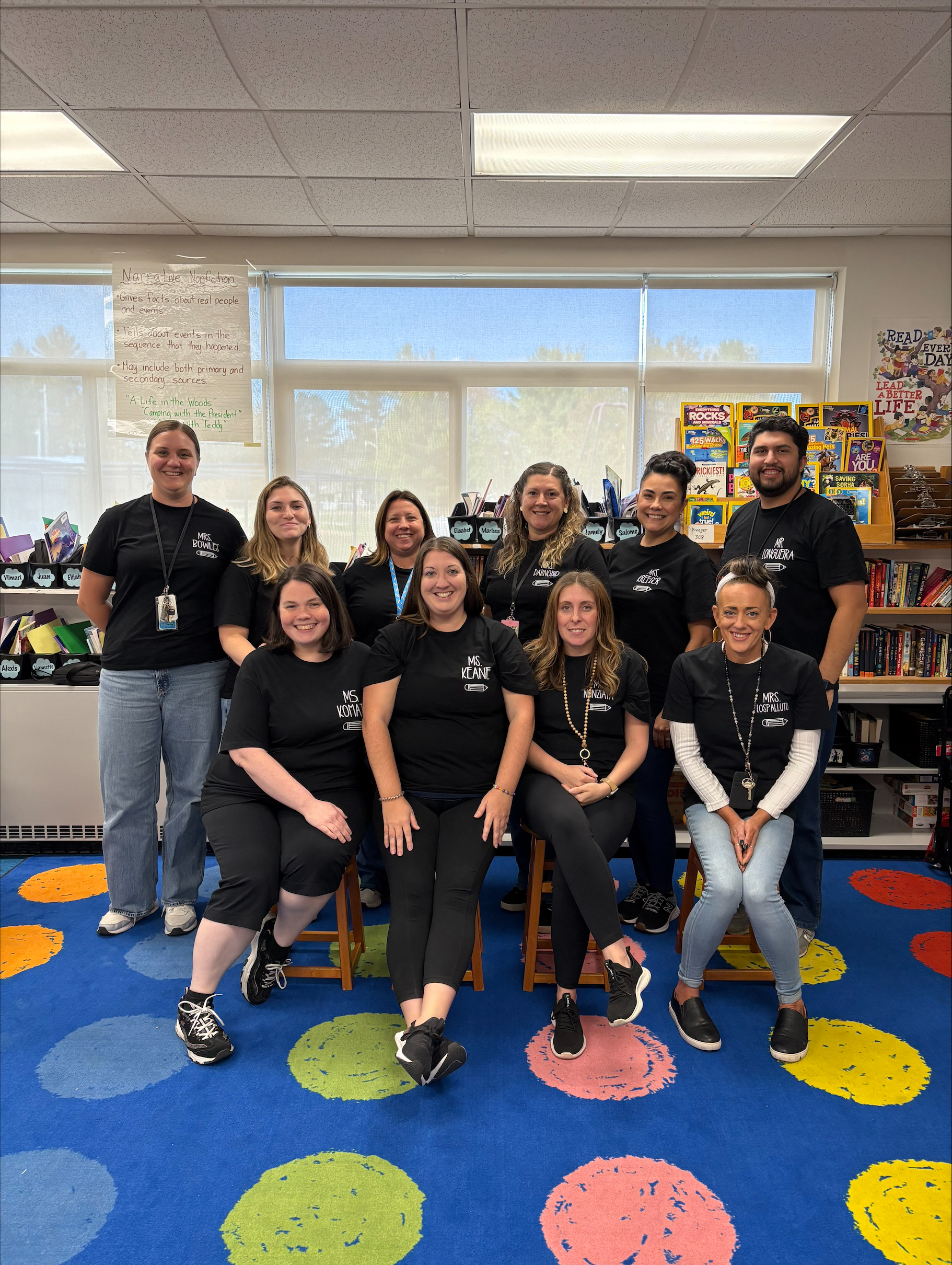 a group of teachers pose in matching t shirts