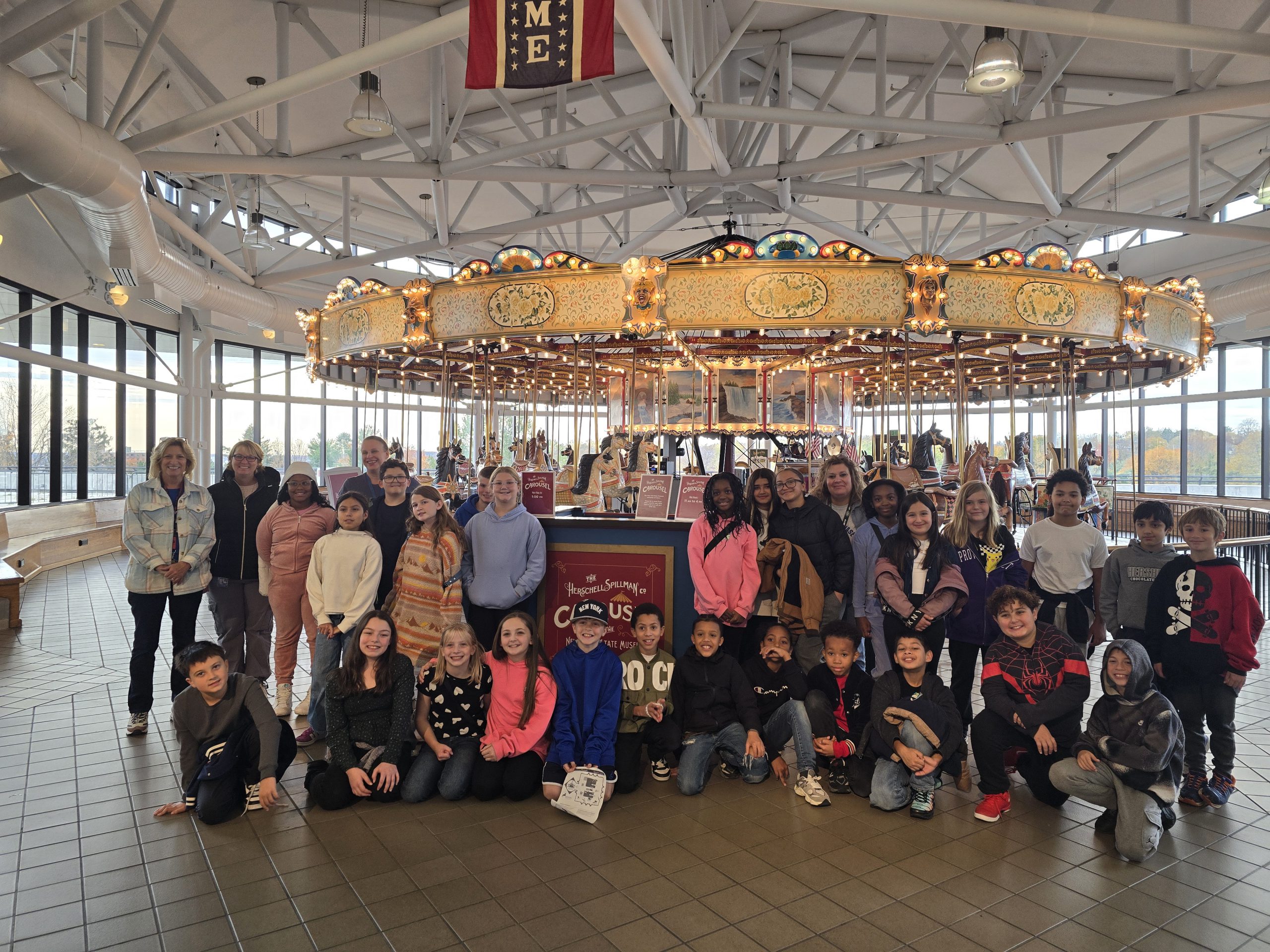 students pose in front of a carosel 