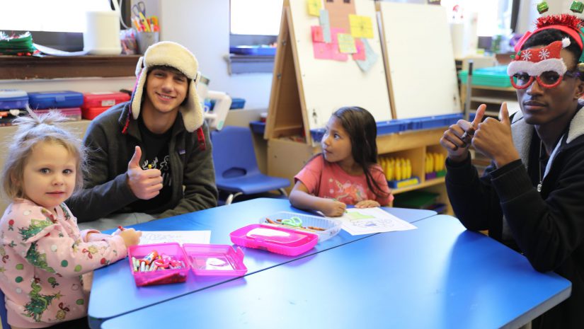 students are seated at a table engaged in an activity