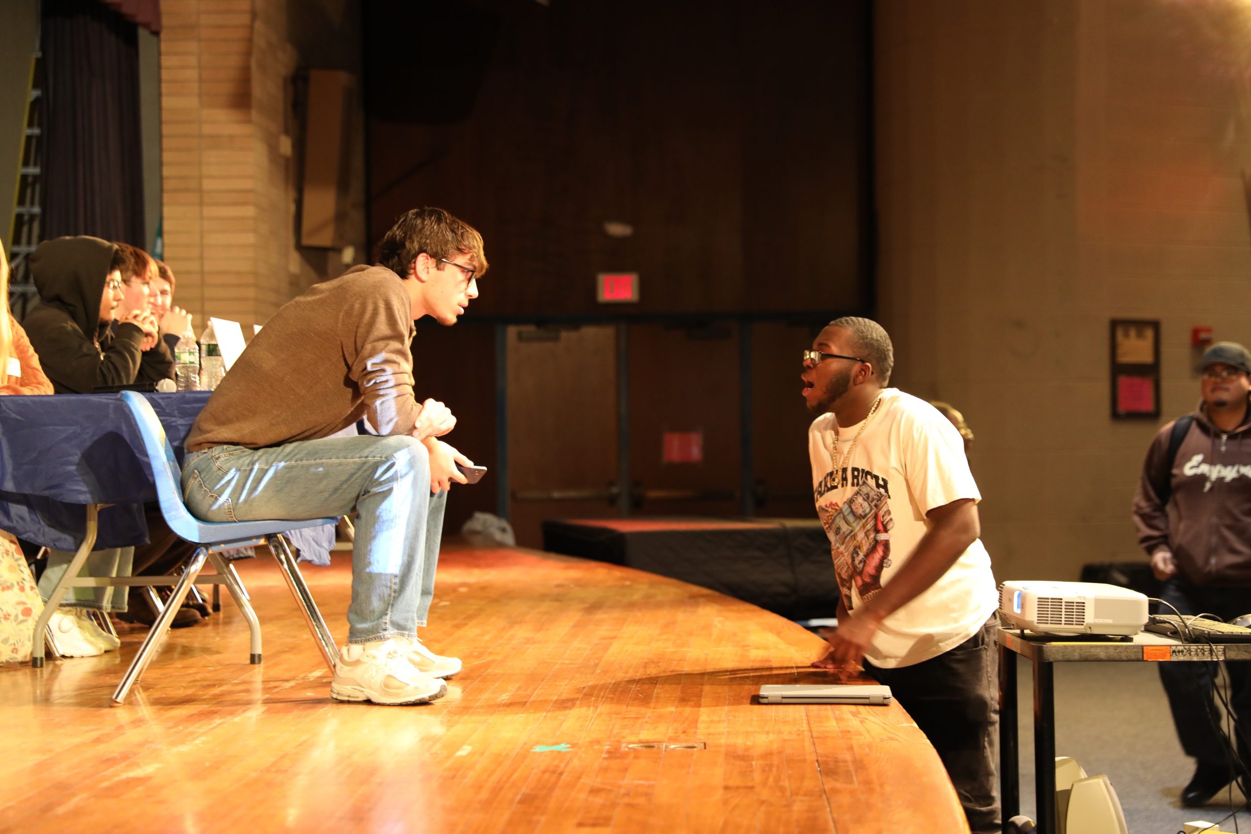 a student speaks to one of the panelists seated on stage