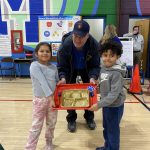 two students hold up a trophy