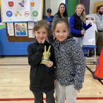 two students hold up a trophy