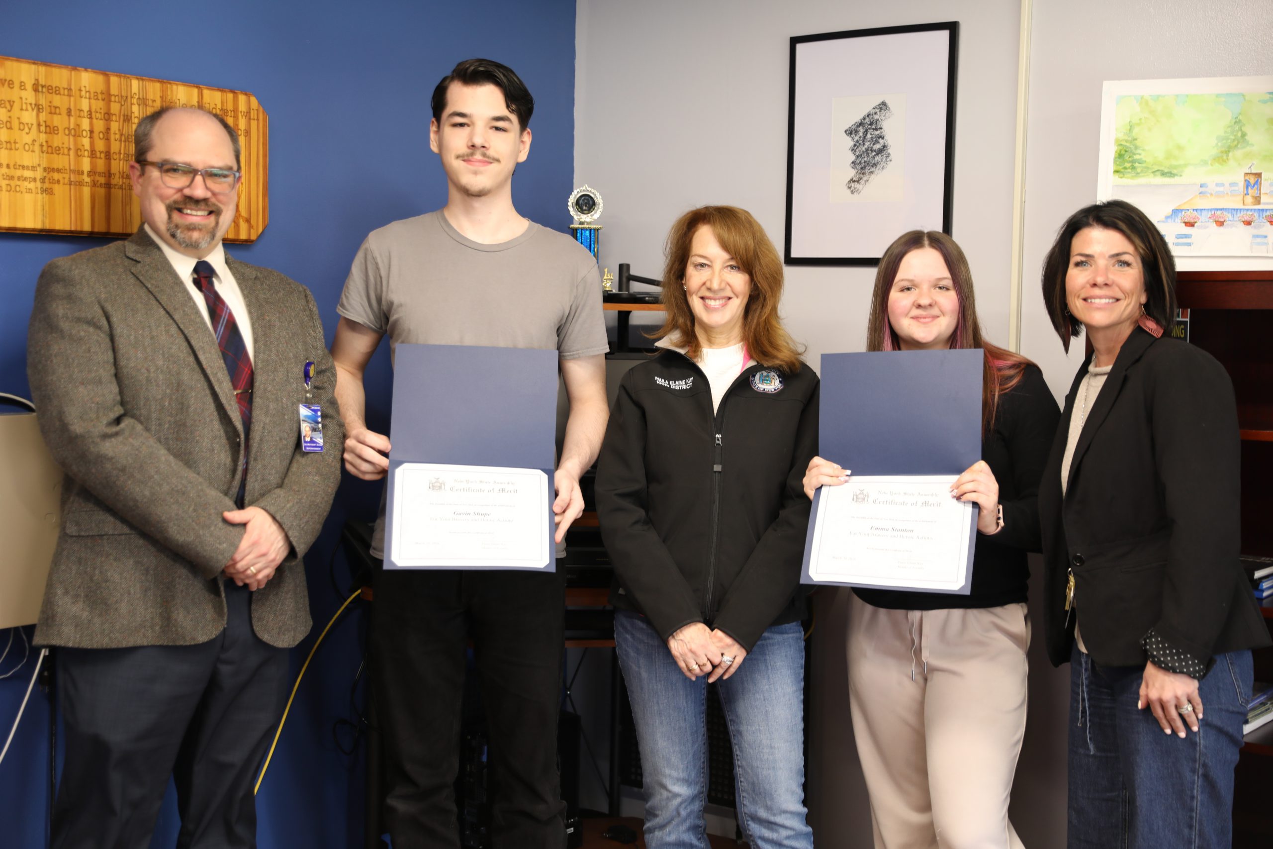 a group of people pose in a principals office