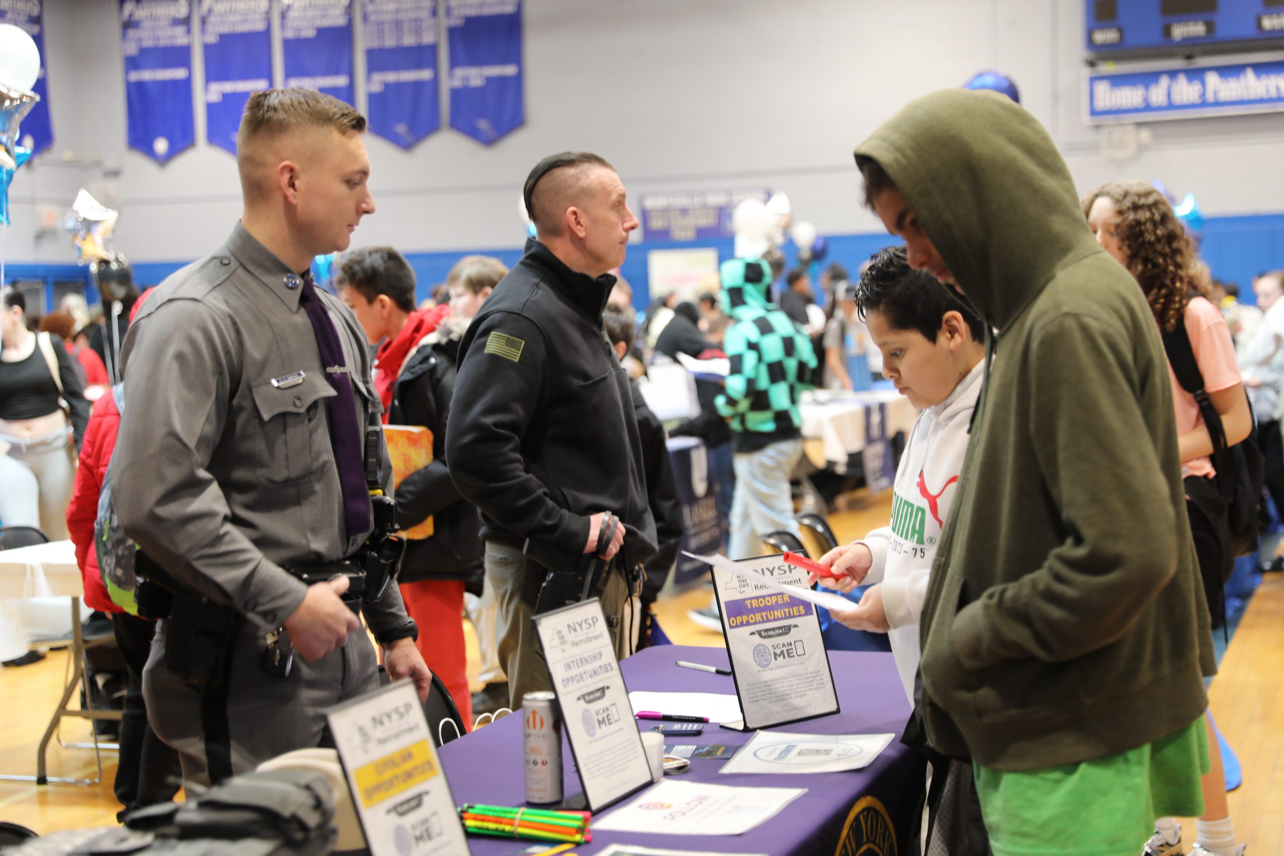students speak to police at a vendor booth at the career fair