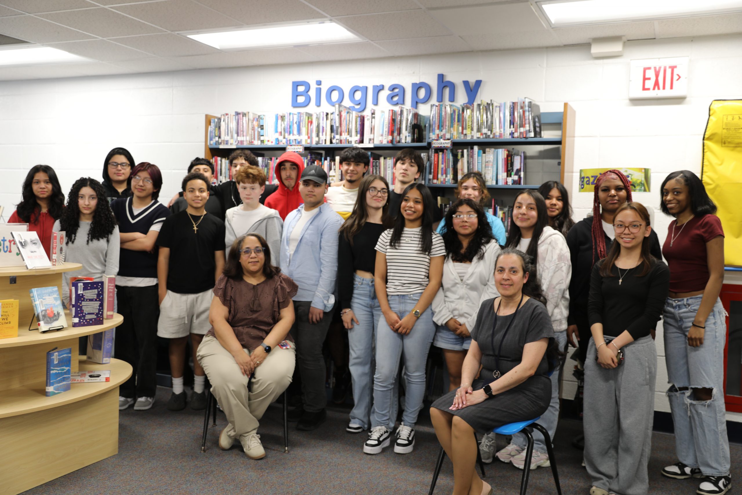 a group of students are posing with their teachers in the high school library