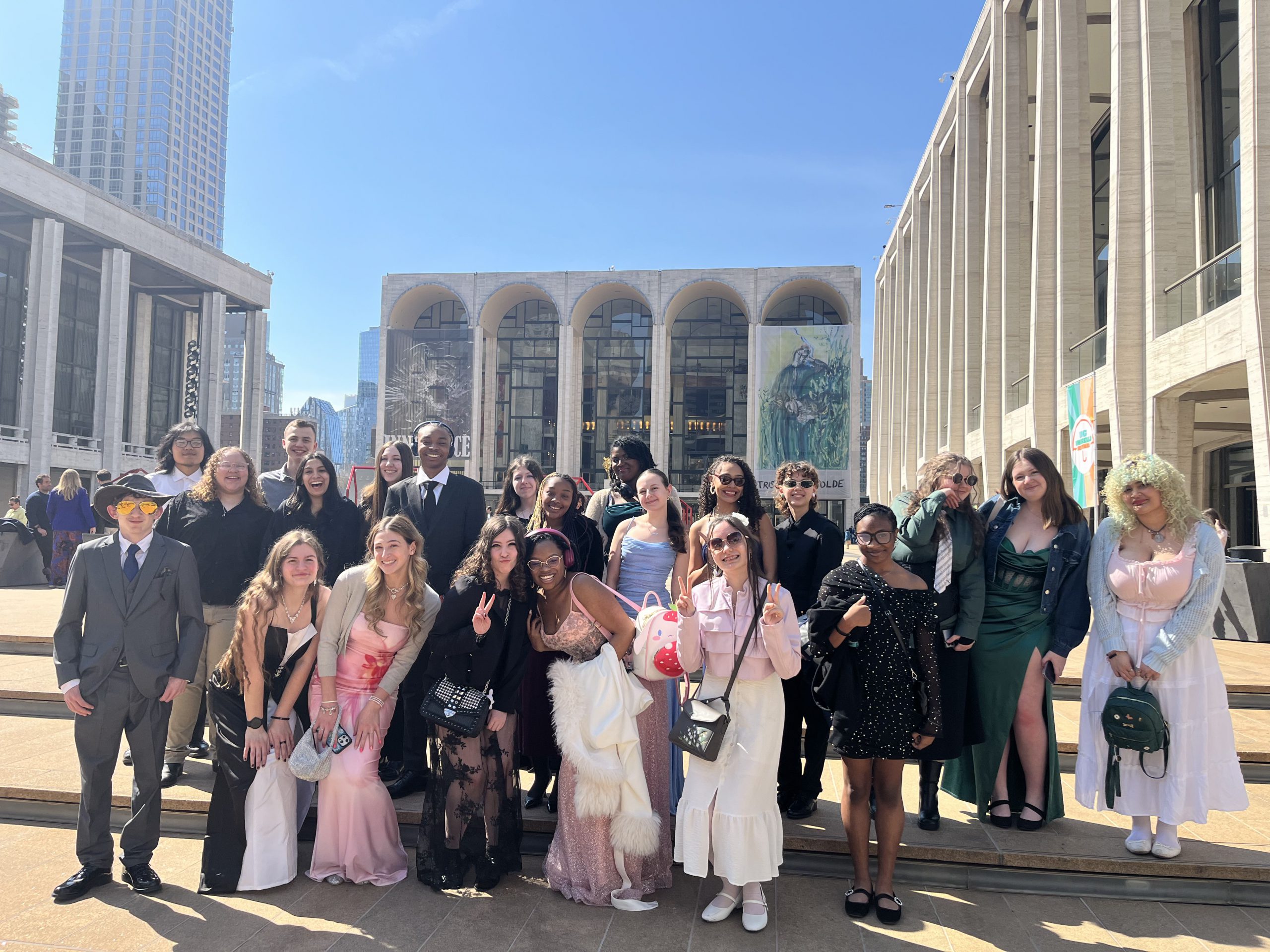 a group of students pose outside of the metropolitan opera house