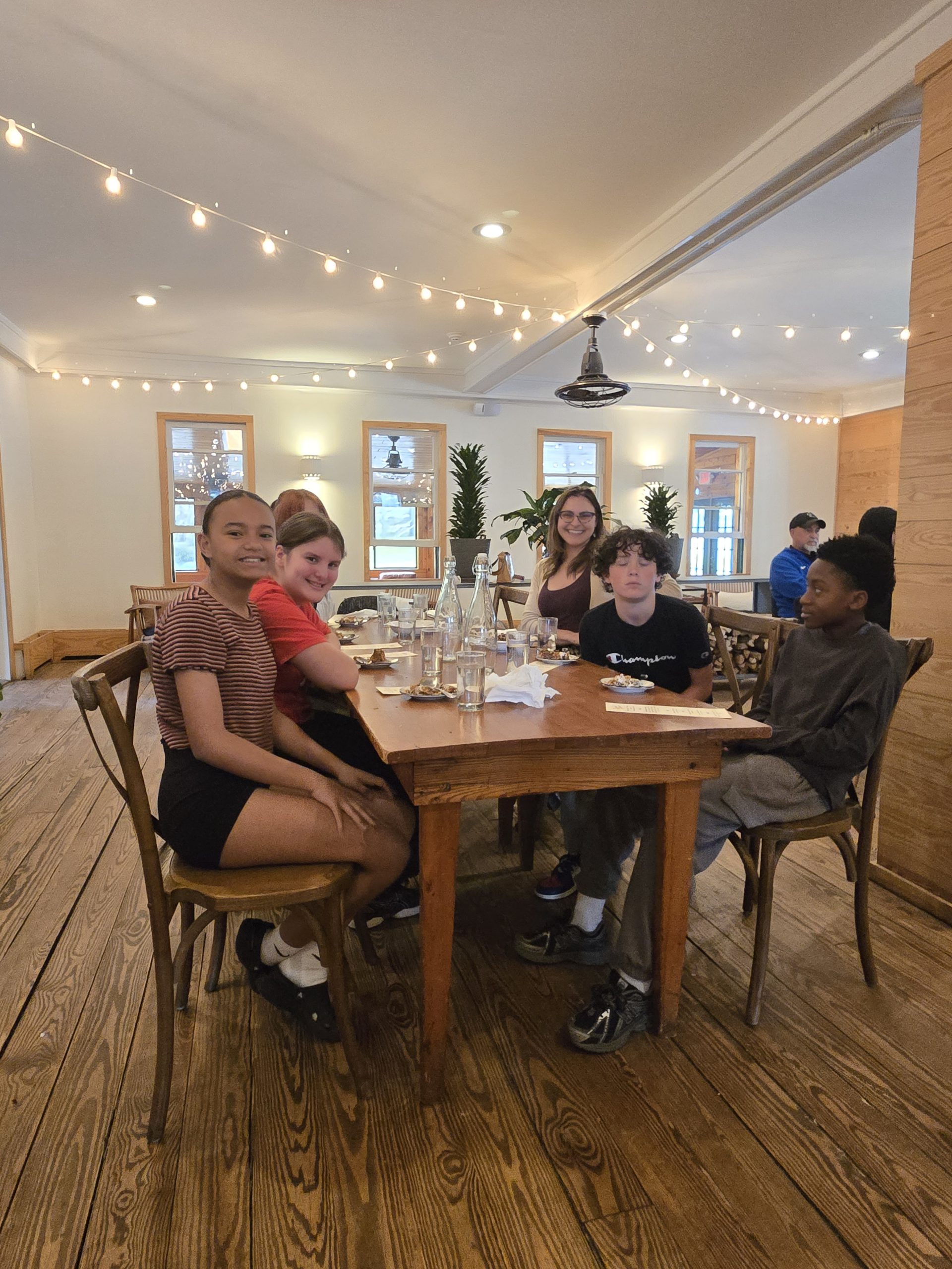 a group of students are seated around a dining table