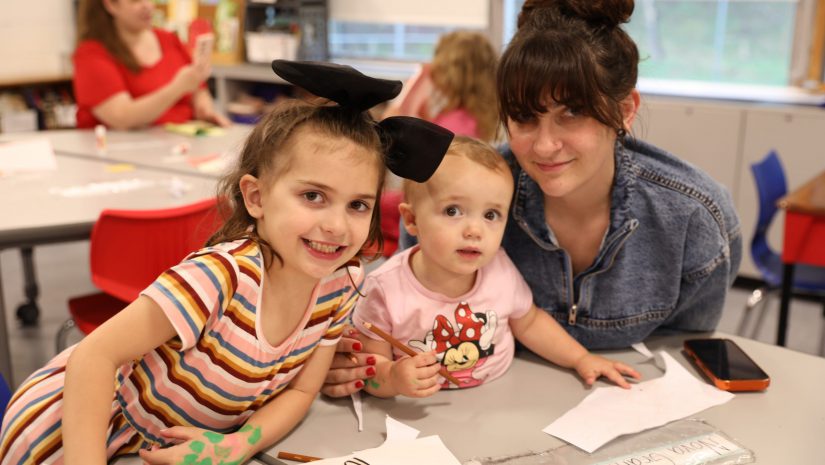 a family is smiling for the camera as they work on a craft together