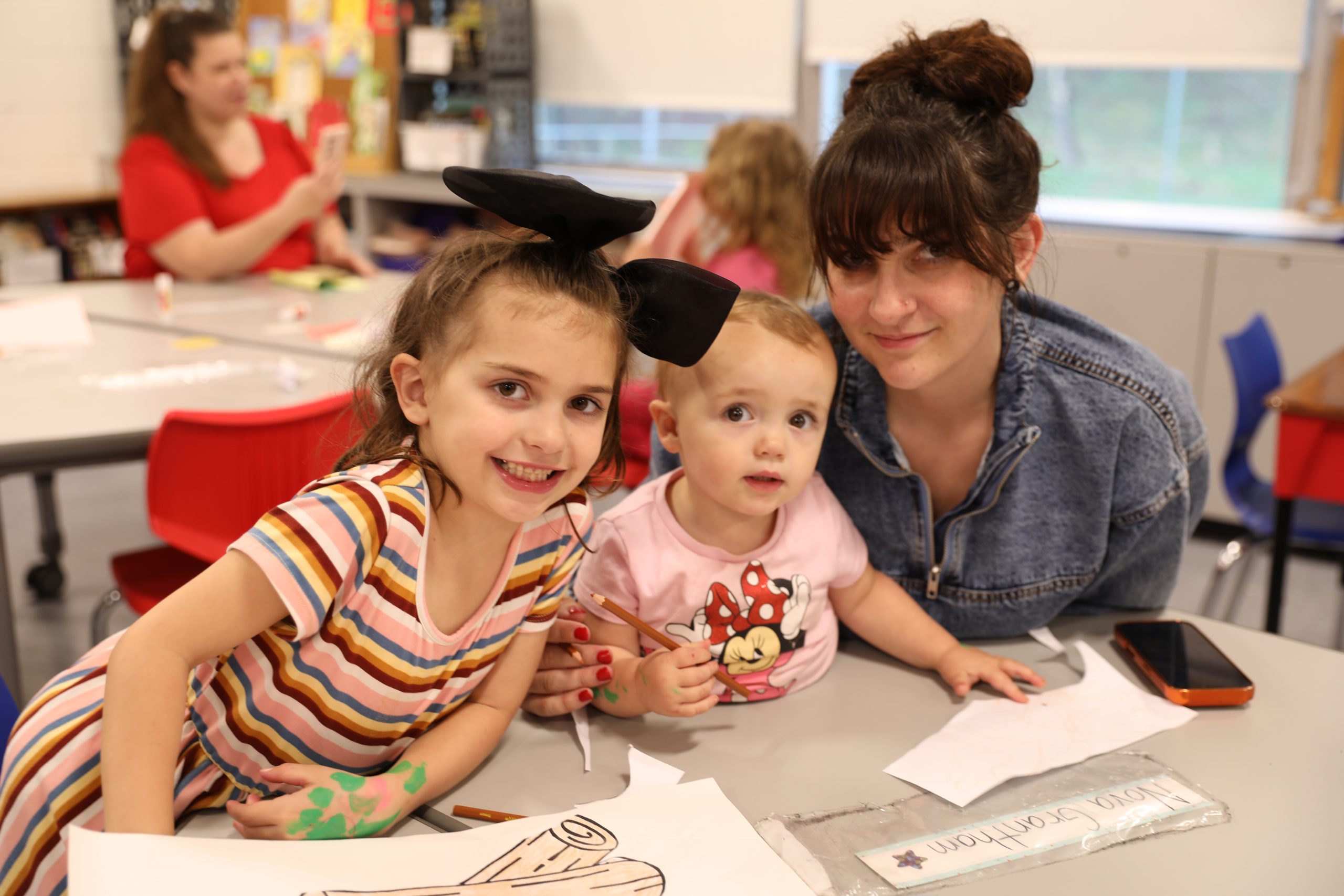 a family is smiling for the camera as they work on a craft together