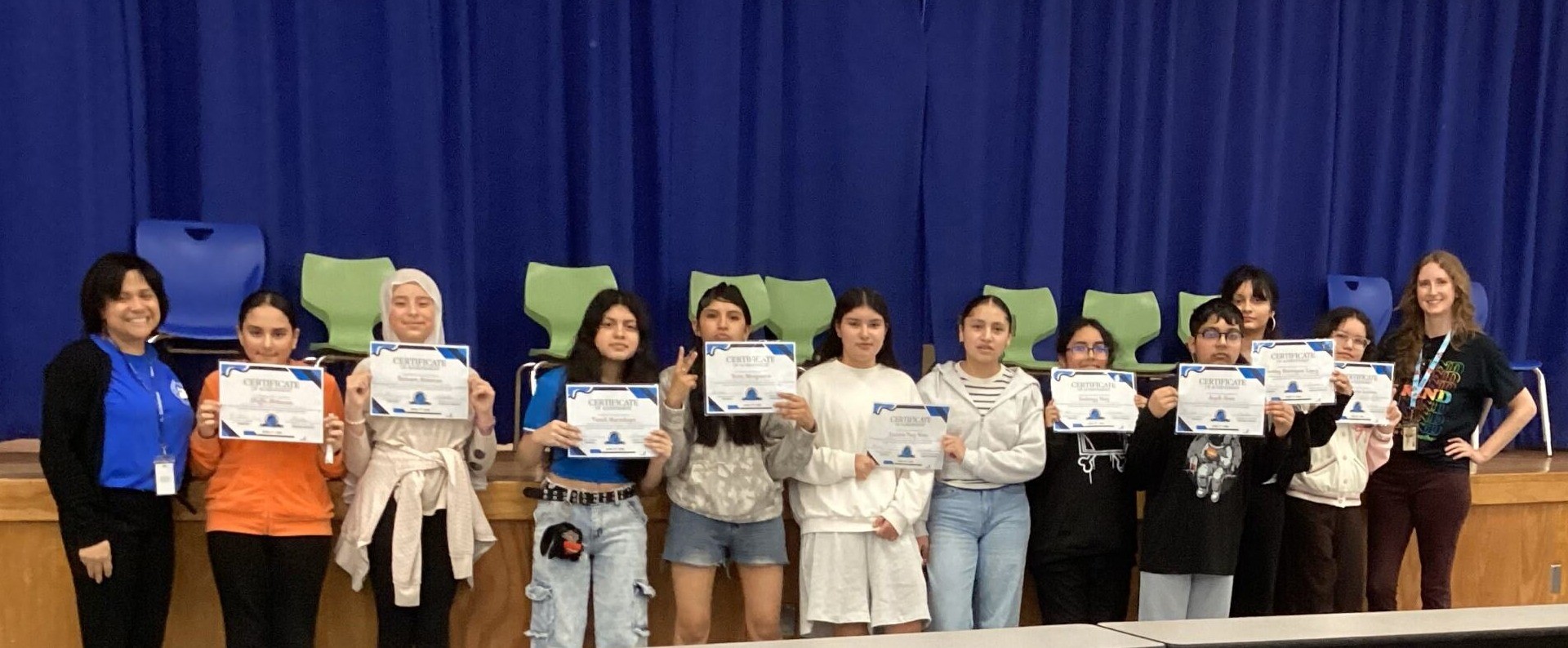 a group of students pose holding certificates
