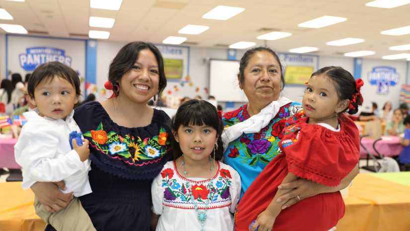 a family wearing traditional clothing from their culture poses for the camera