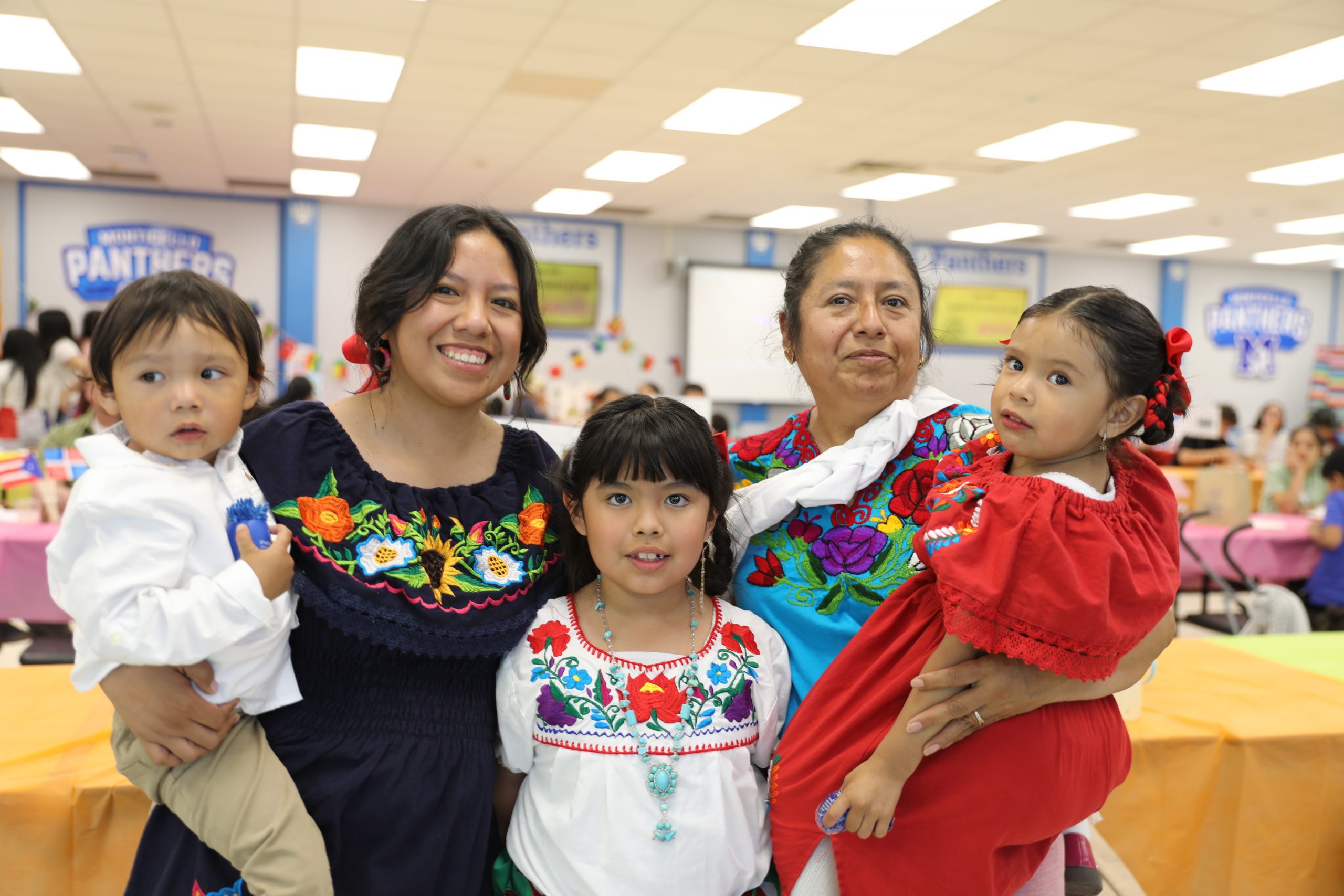a family wearing traditional clothing from their culture poses for the camera